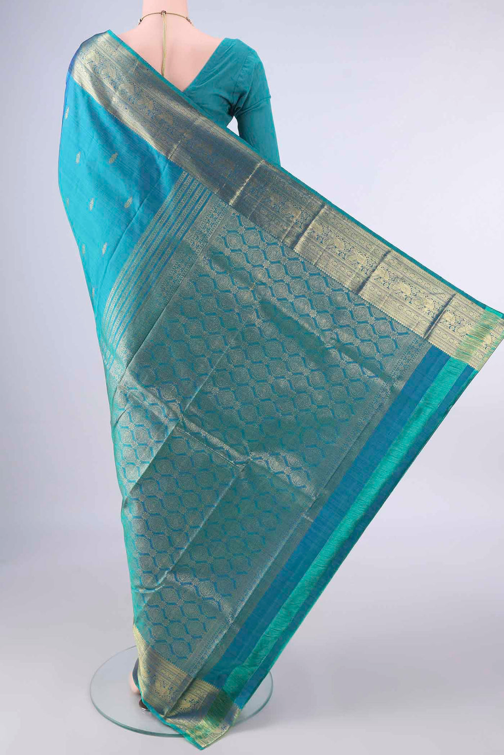 Flat view of Pure Silk Peacock Blue Kanchipuram Saree with Zari Butta on the body and Zari Border. 