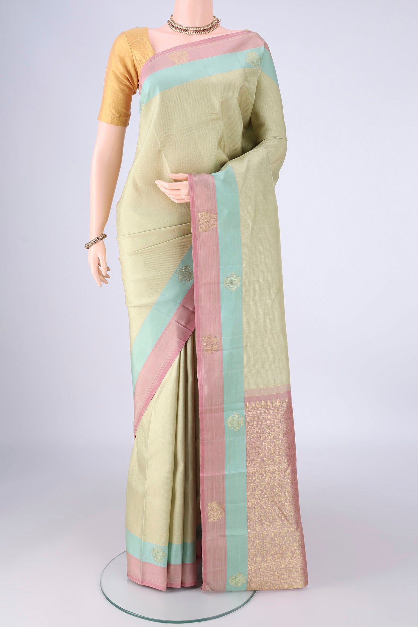 Beige Kanjivaram Silk Saree with Checked design on the body and Zari Border.  displayed on a mannequin