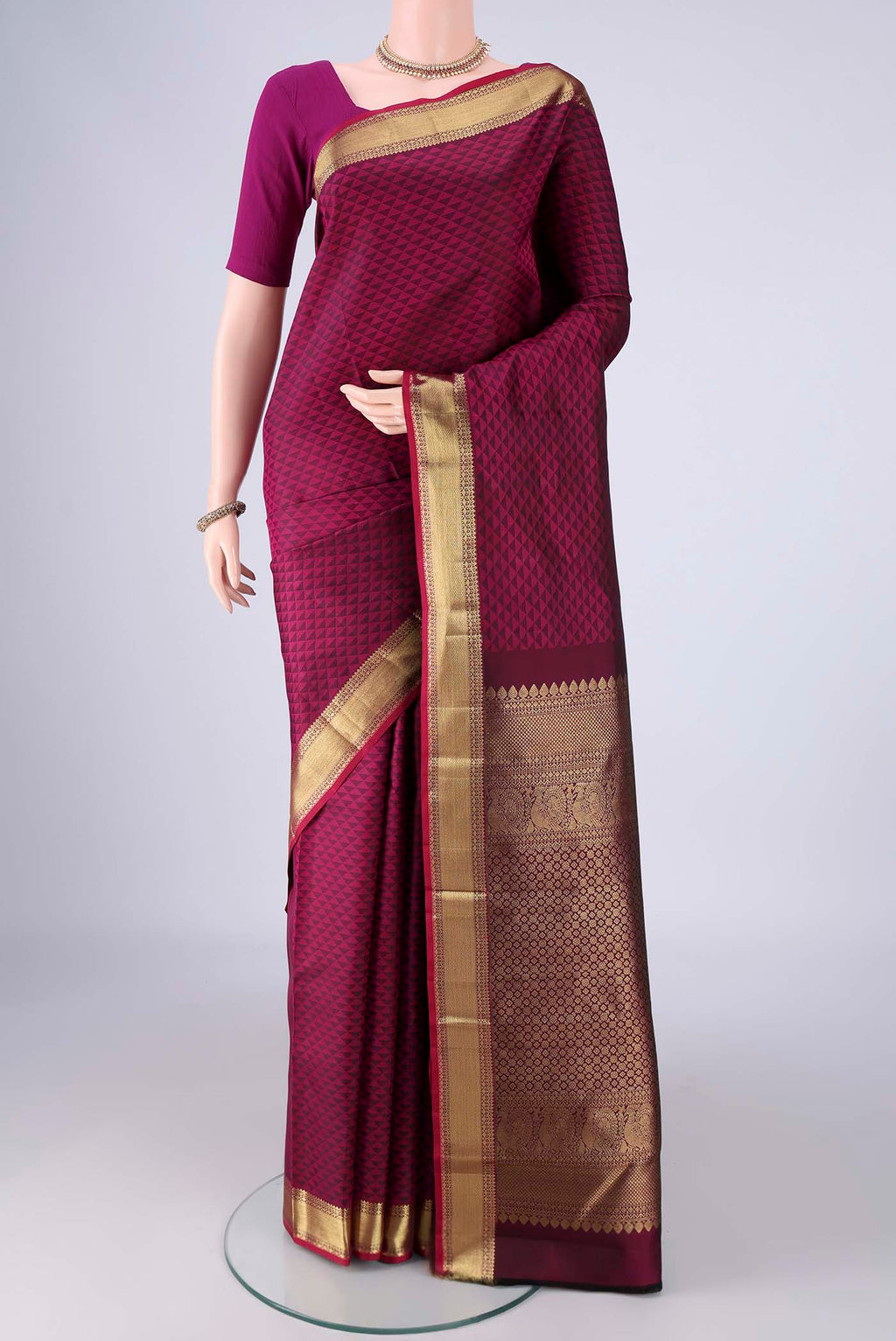 Magenta Kanjivaram Silk Saree with Jacquard design on the body and Zari Border.  displayed on a mannequin