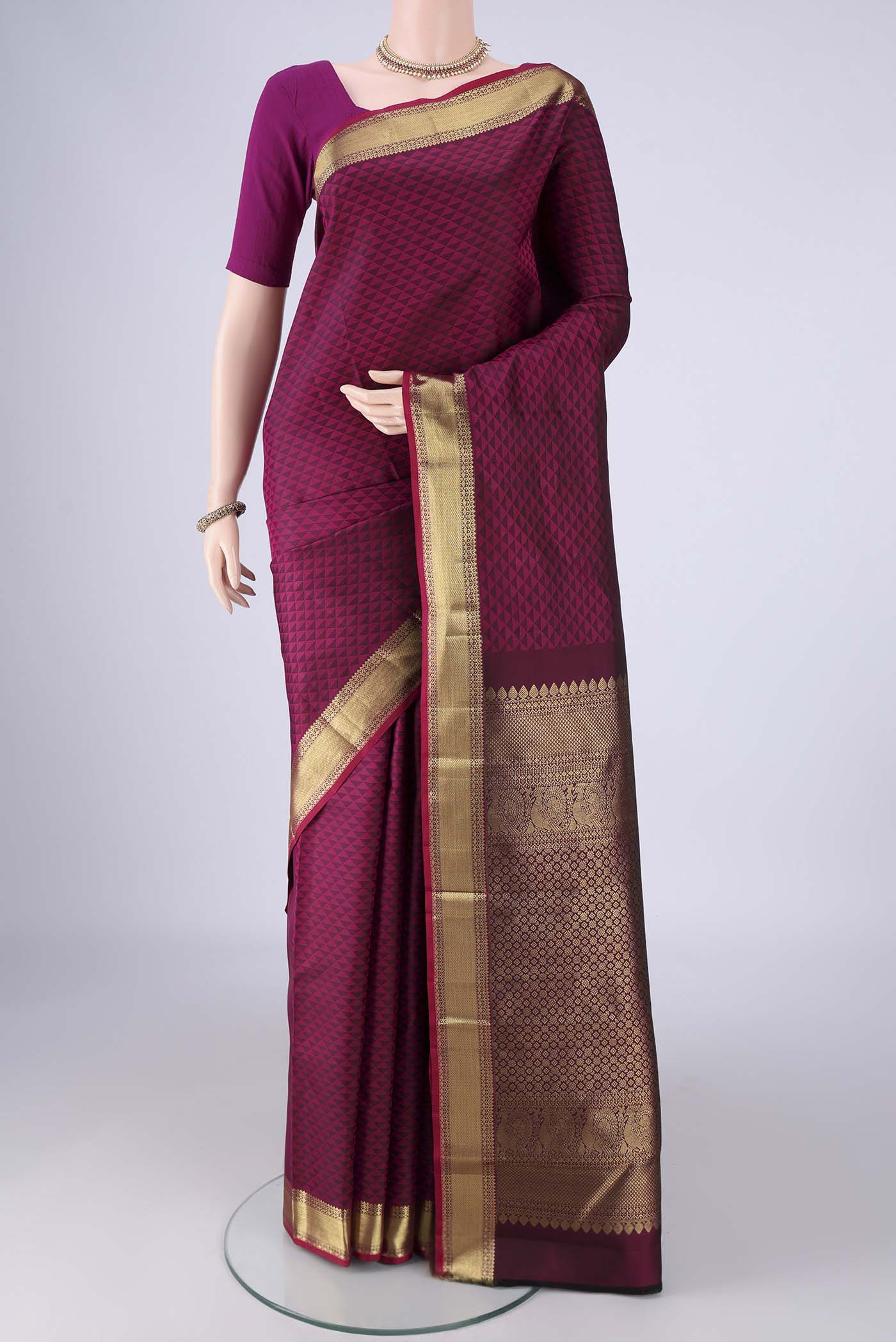 Magenta Kanjivaram Silk Saree with Jacquard design on the body and Zari Border.  displayed on a mannequin