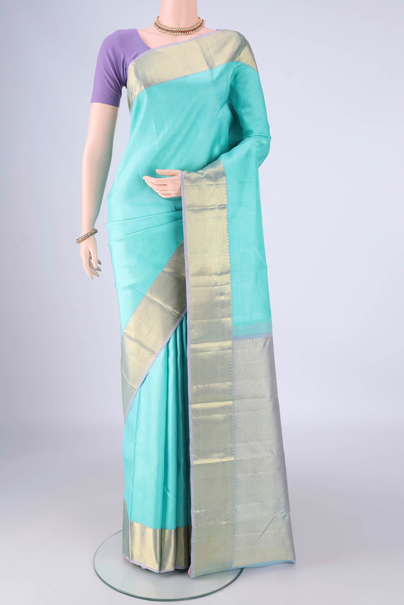 Turquoise Kanjivaram Silk Saree with Jacquard design on the body and Zari Border.  displayed on a mannequin