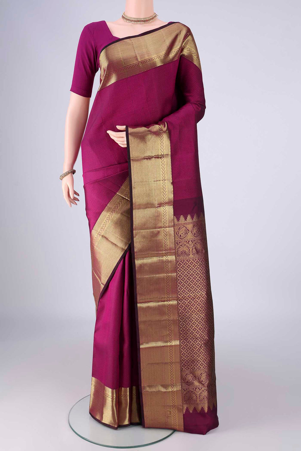Magenta Kanjivaram Silk Saree with Jacquard design on the body and Zari Border.  displayed on a mannequin