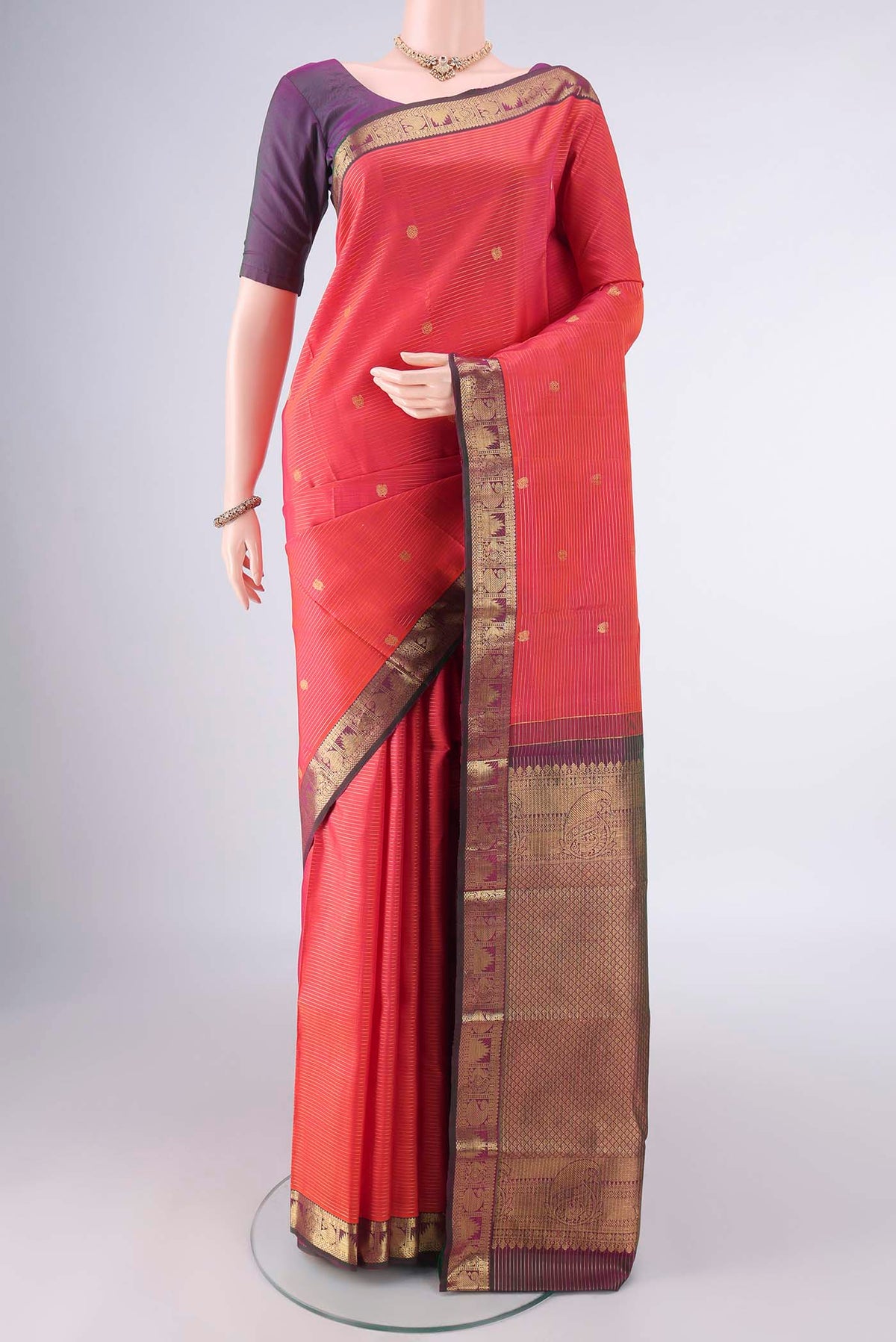 Pure Silk Orange Kanchipuram Saree with Stripes on the body and Zari Border.  displayed on a mannequin
