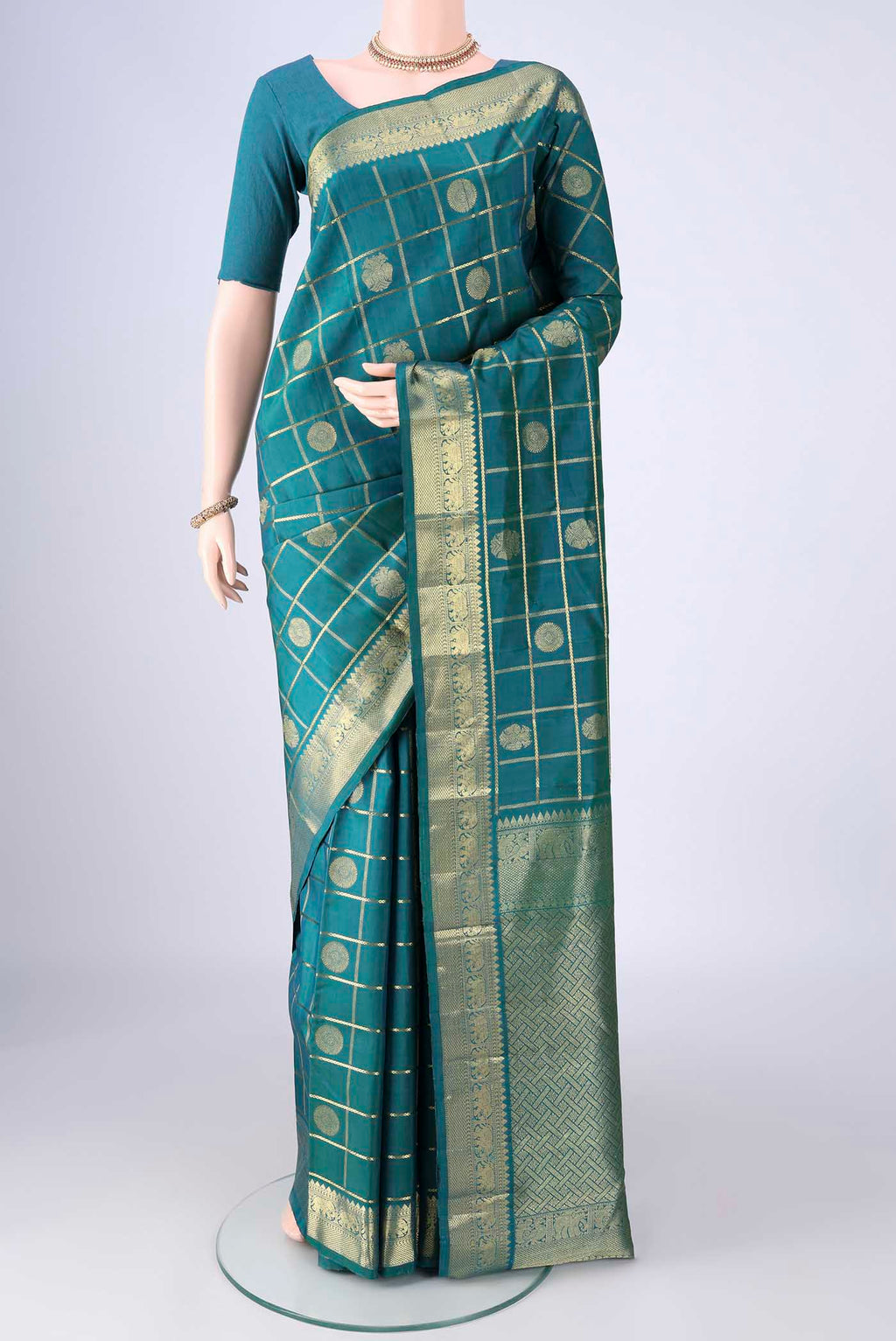 Peacock Blue Kanjivaram Silk Saree with Checked design on the body and Zari Border.  displayed on a mannequin