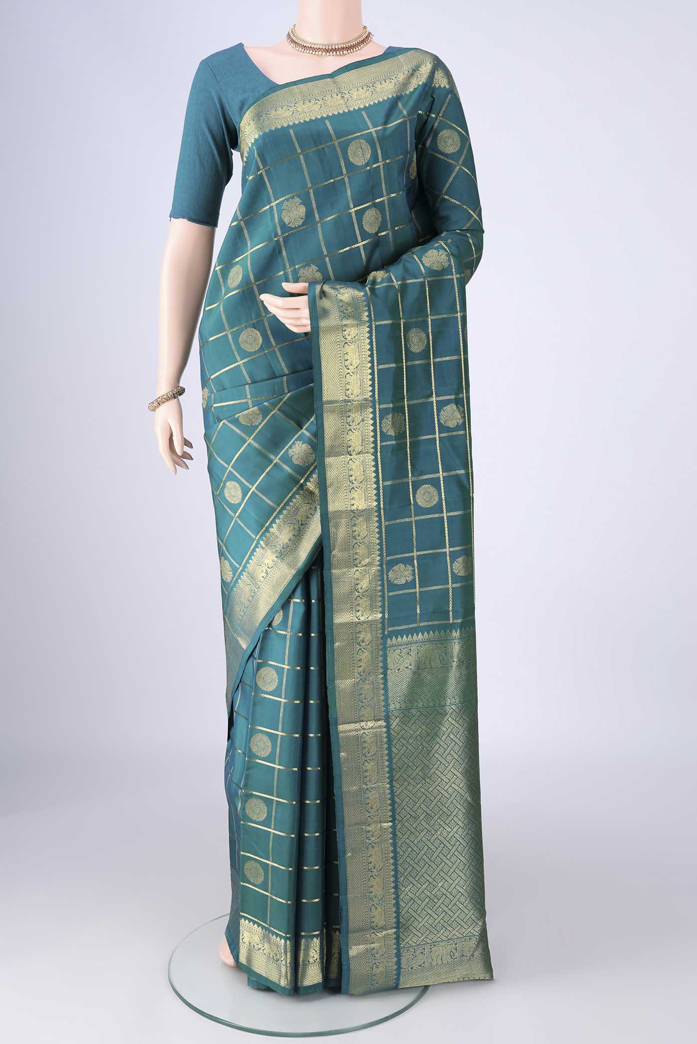 Peacock Blue Kanjivaram Silk Saree with Checked design on the body and Zari Border.  displayed on a mannequin