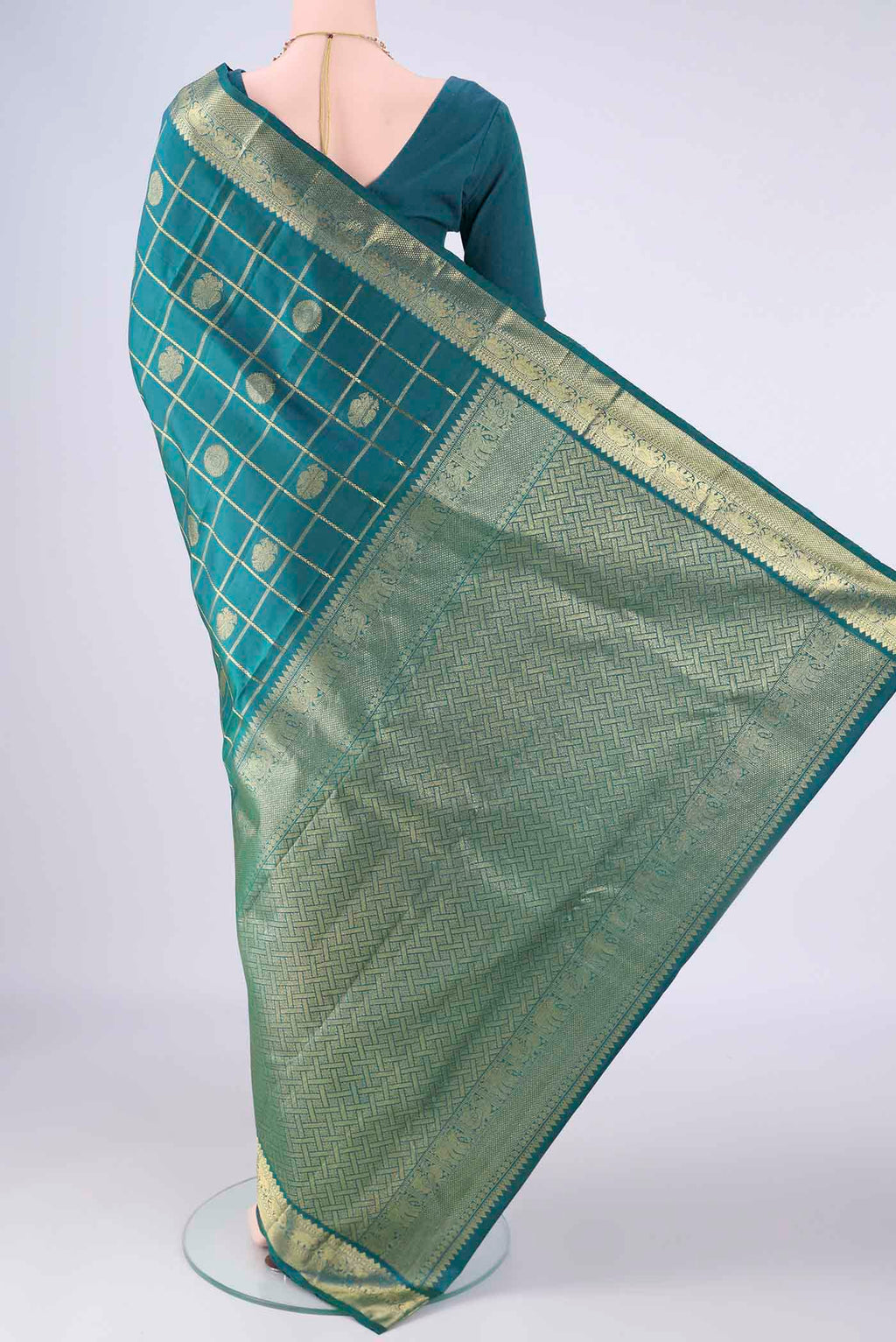 Flat view of Peacock Blue Kanjivaram Silk Saree with Checked design on the body and Zari Border. 