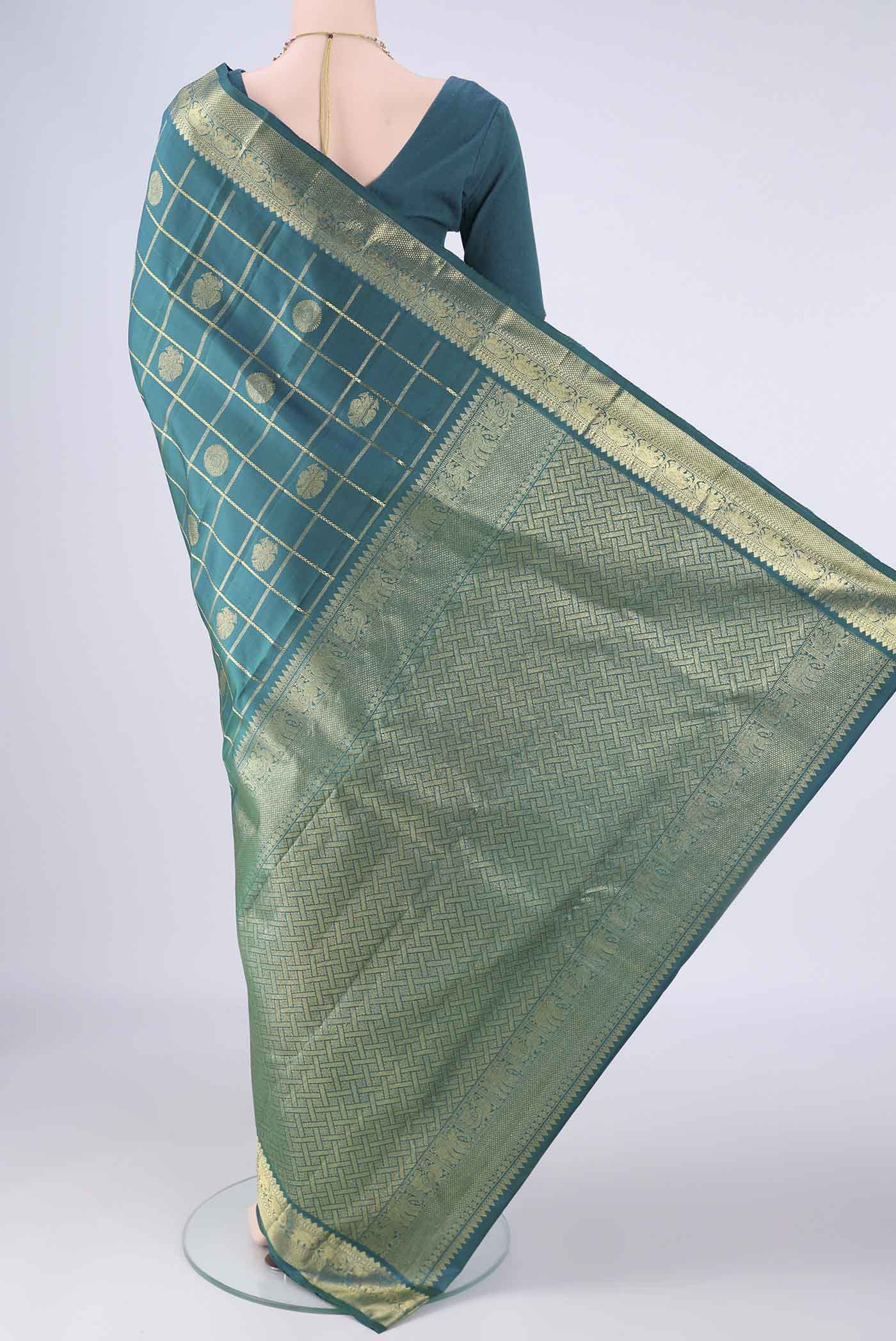 Flat view of Peacock Blue Kanjivaram Silk Saree with Checked design on the body and Zari Border. 
