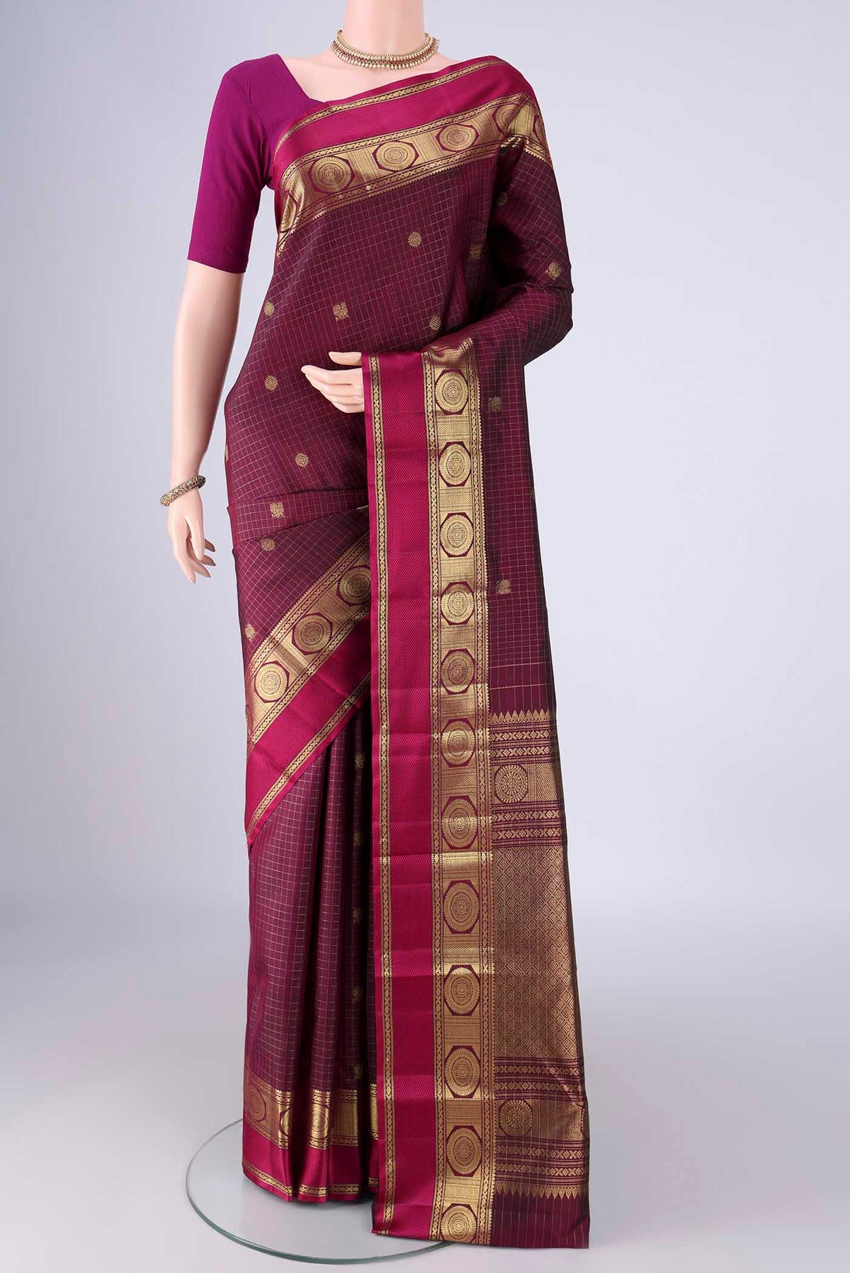 Maroon Kanjivaram Silk Saree with Checked design on the body and Zari And Thread Border.  displayed on a mannequin