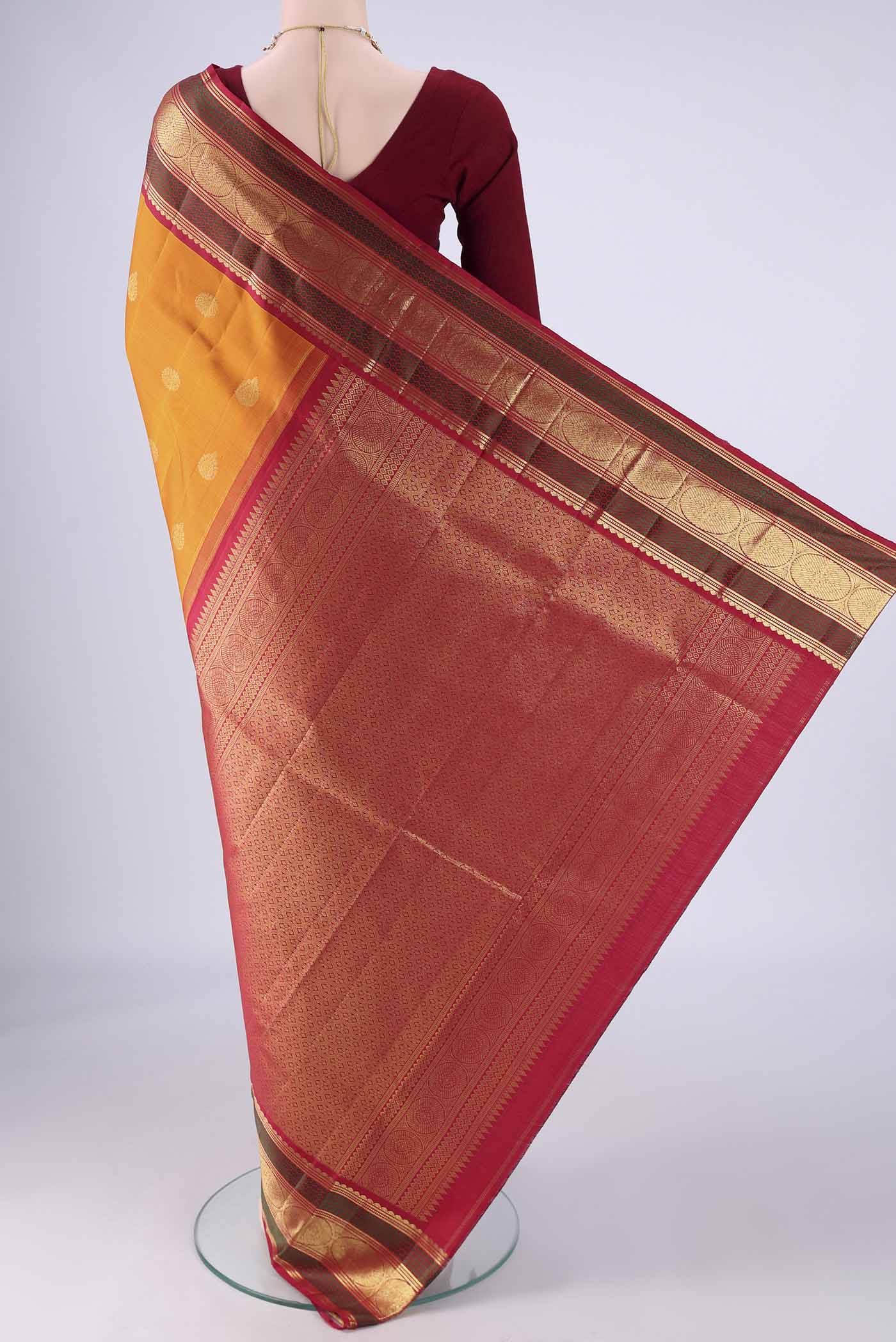 Flat view of Mustard Kanchipuram Silk Saree with Zari Butta on the body and Zari And Thread Border. 