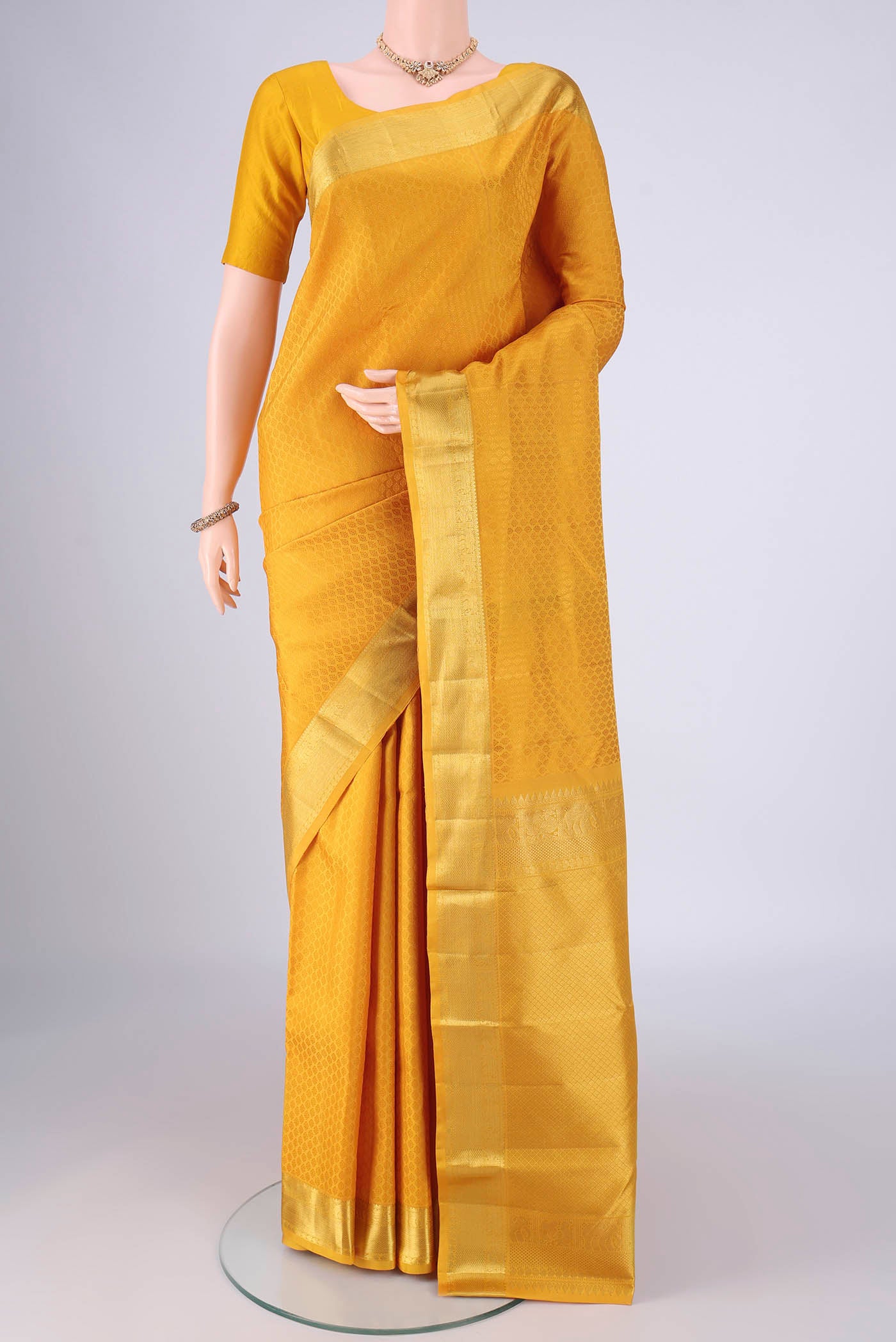 Yellow Kanjivaram Silk Saree with Jacquard design on the body and Zari Border.  displayed on a mannequin