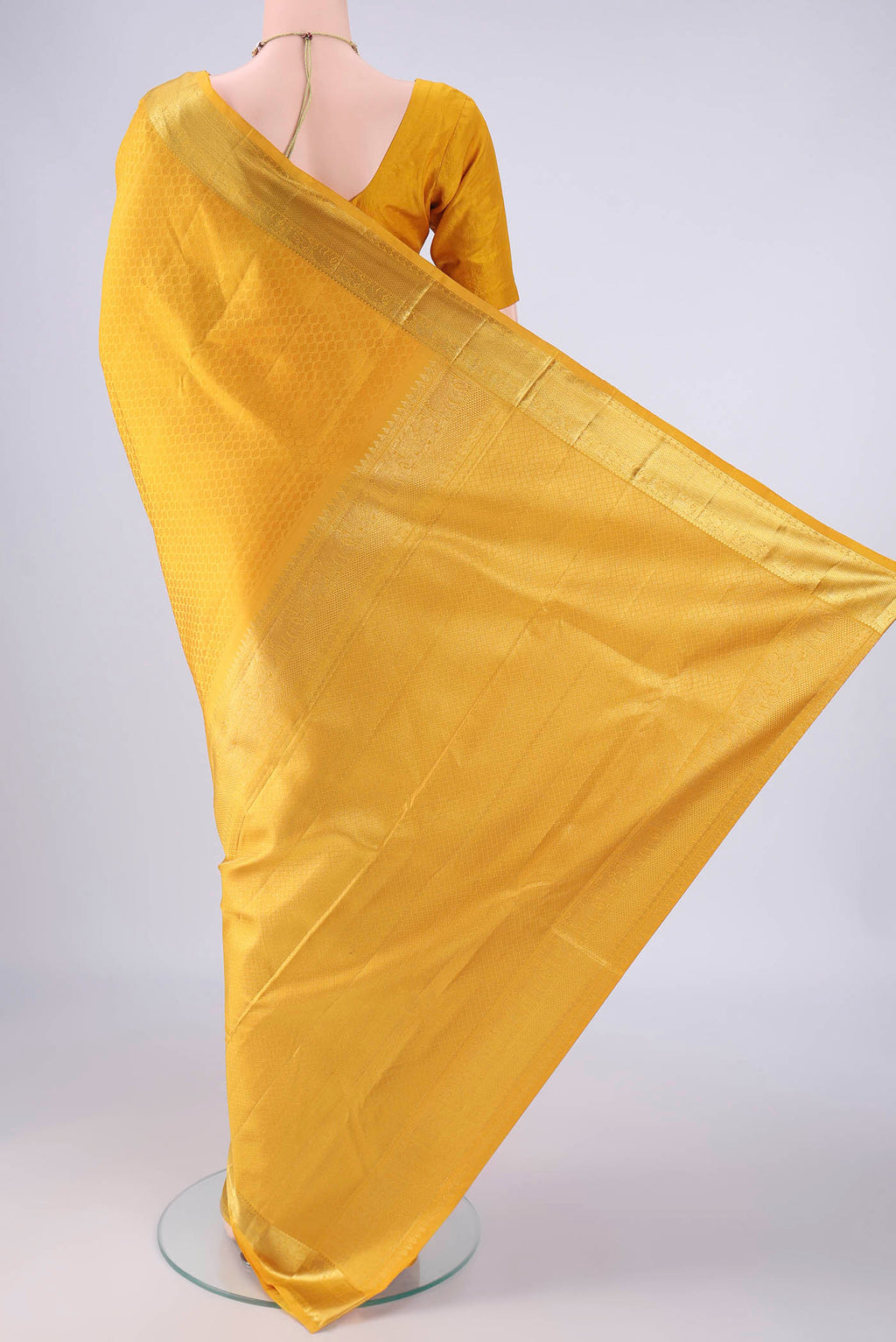 Flat view of Yellow Kanjivaram Silk Saree with Jacquard design on the body and Zari Border. 