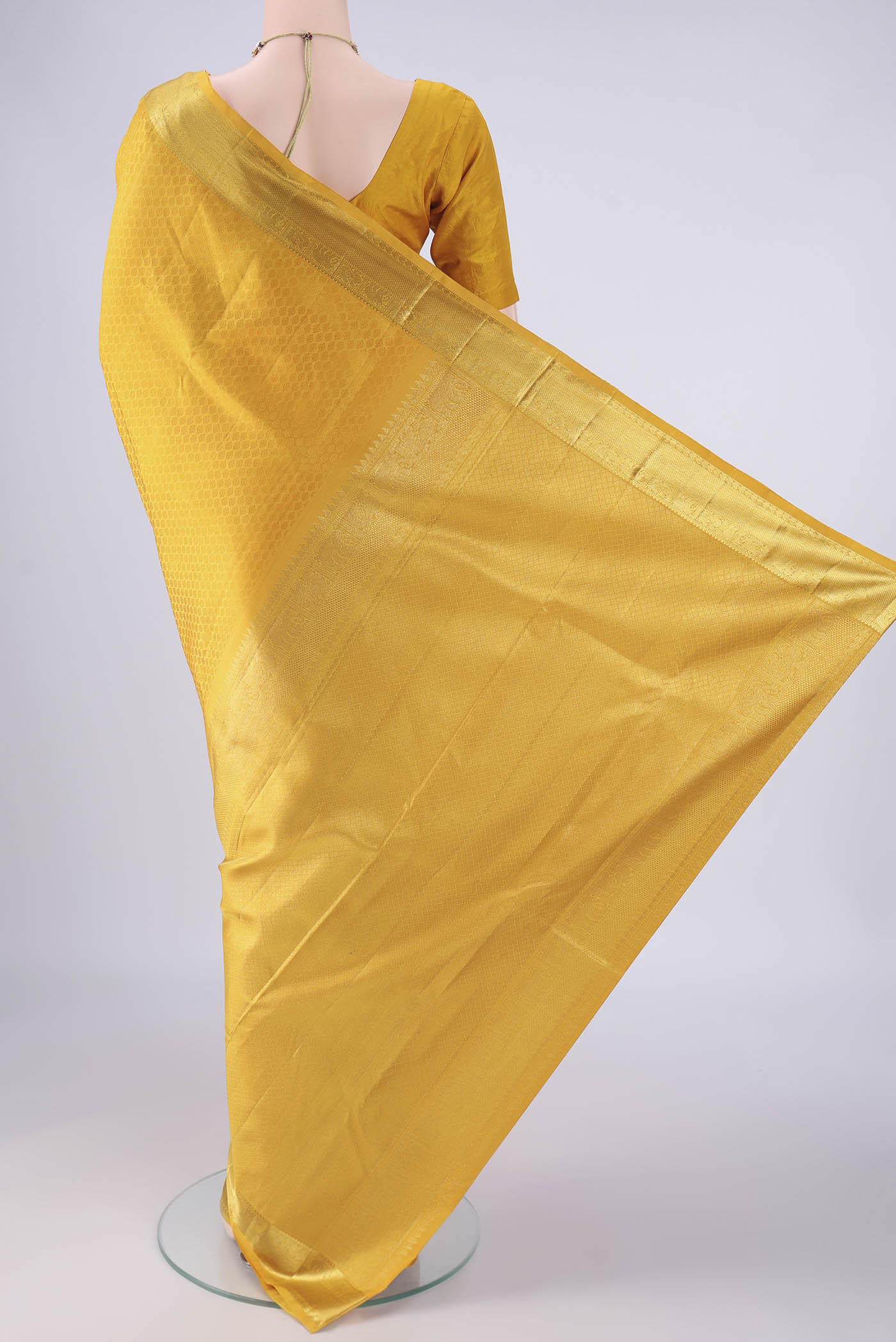 Flat view of Yellow Kanjivaram Silk Saree with Jacquard design on the body and Zari Border. 