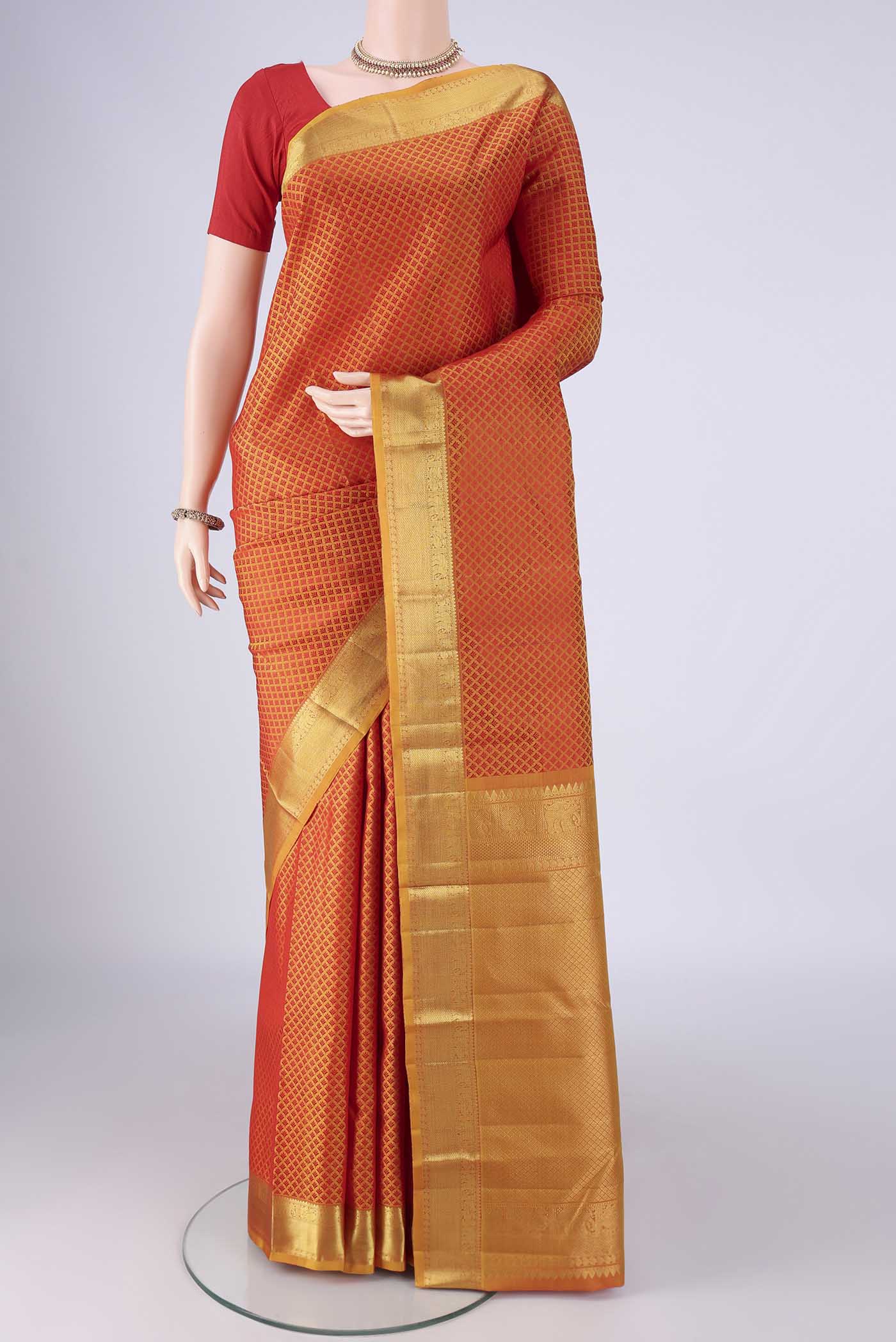 Mustard Kanjivaram Silk Saree with Jacquard design on the body and Zari Border.  displayed on a mannequin