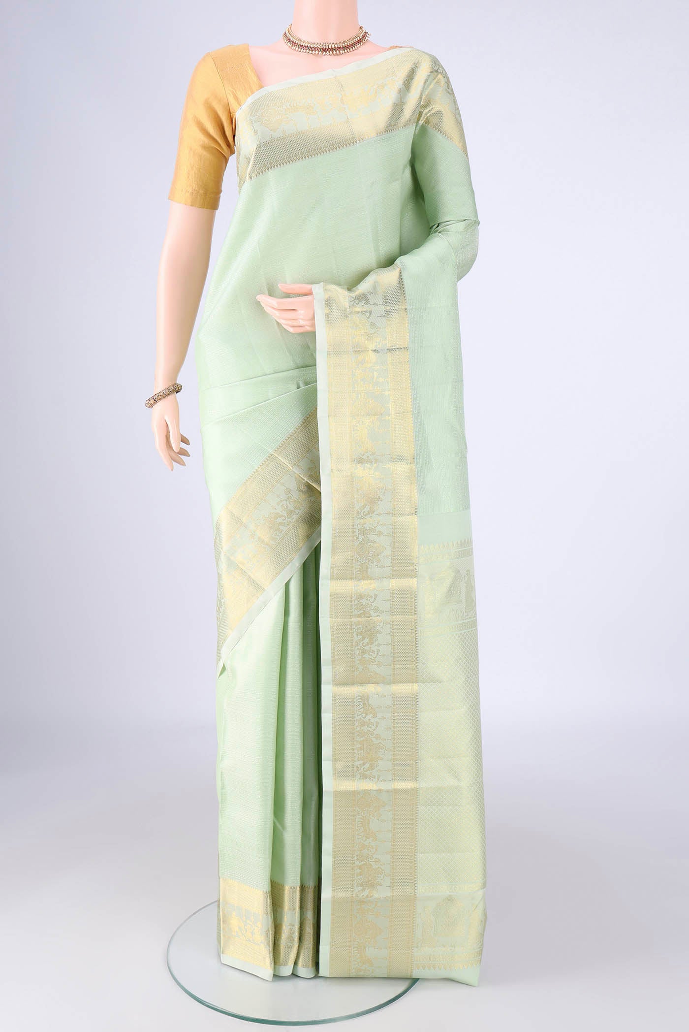 Mint Green Kanjivaram Silk Saree with Jacquard design on the body and Zari Border.  displayed on a mannequin