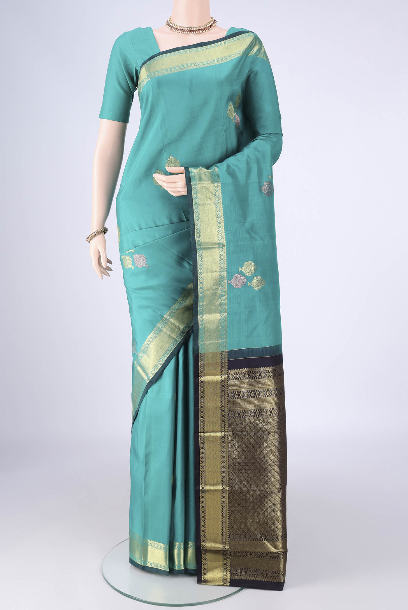 Sea Green Kanchipuram Silk Saree with Zari Butta on the body and Zari Border.  displayed on a mannequin