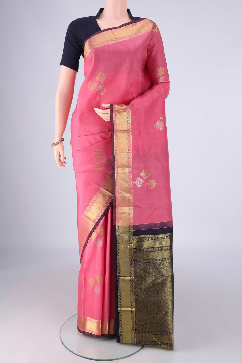 Rose pink Kanchipuram Silk Saree with Zari Butta on the body and Zari Border.  displayed on a mannequin