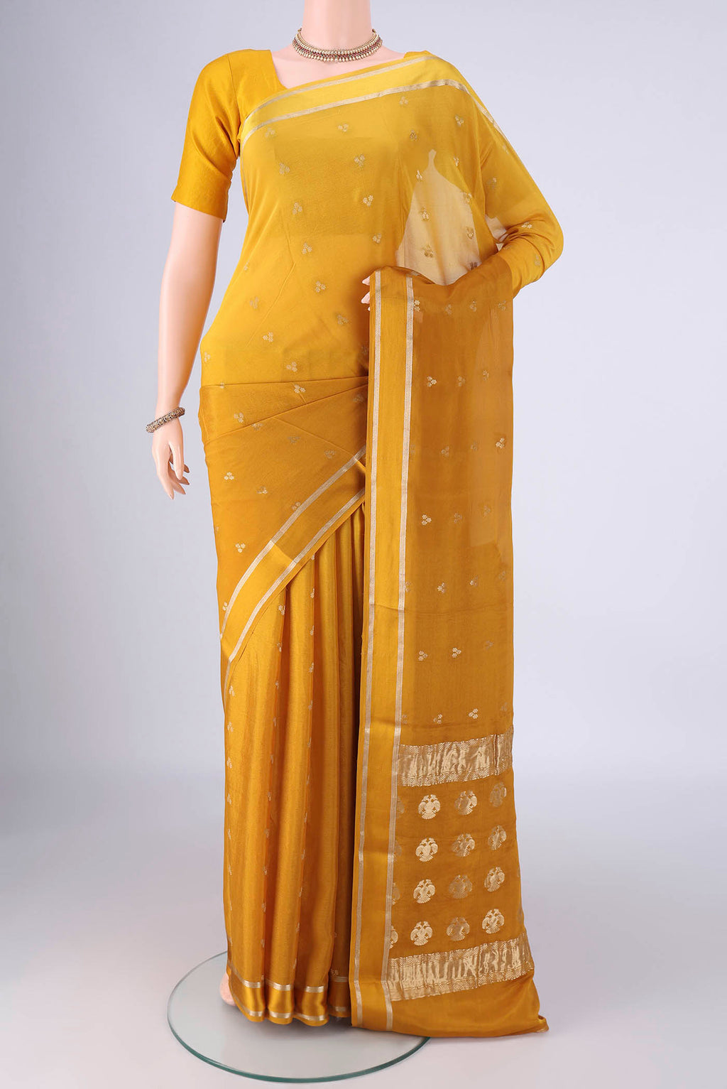 Mustard Mysore Chiffon Saree with Zari Butta on the body and Thin Zari Line.  displayed on a mannequin