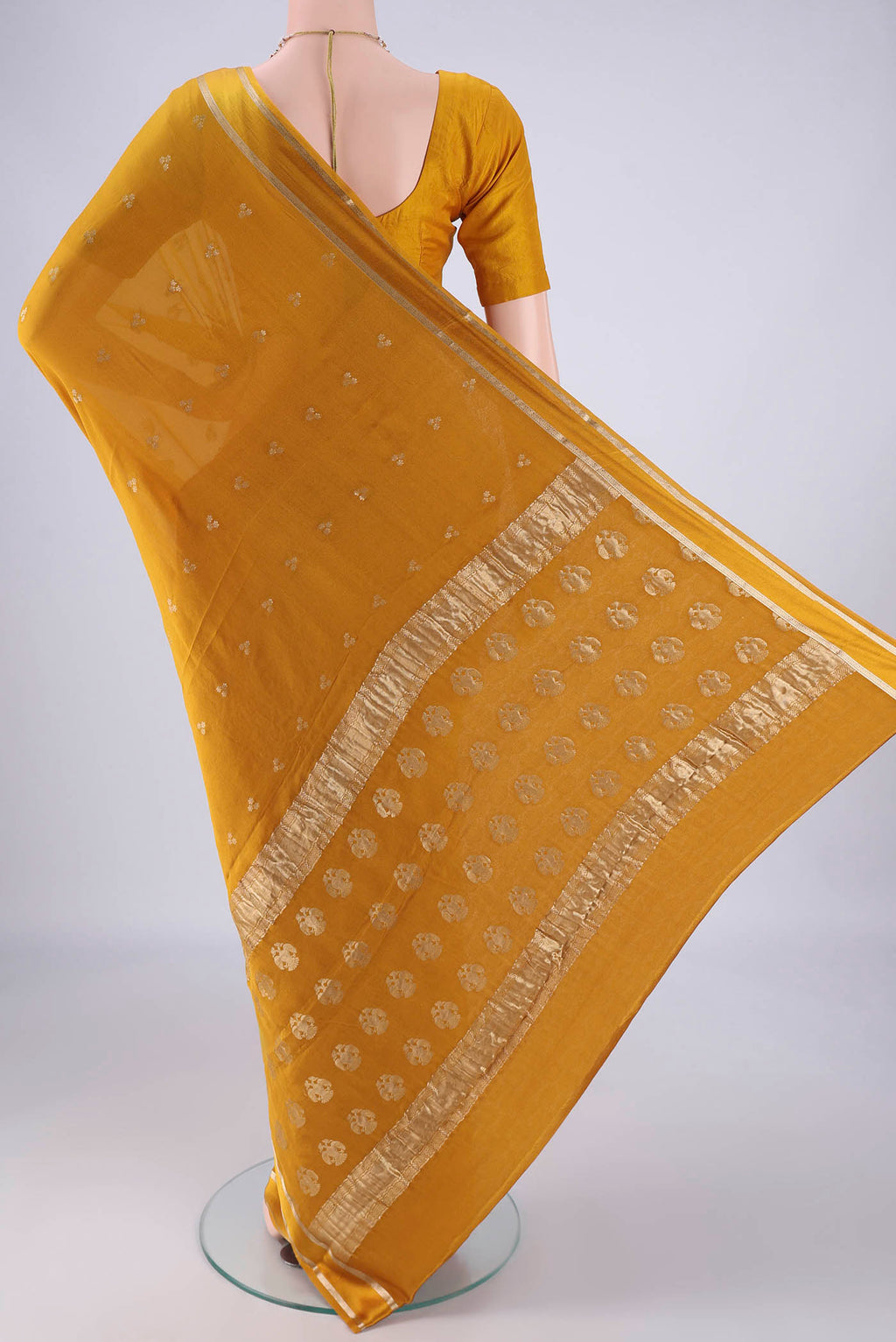 Flat view of Mustard Mysore Chiffon Saree with Zari Butta on the body and Thin Zari Line. 