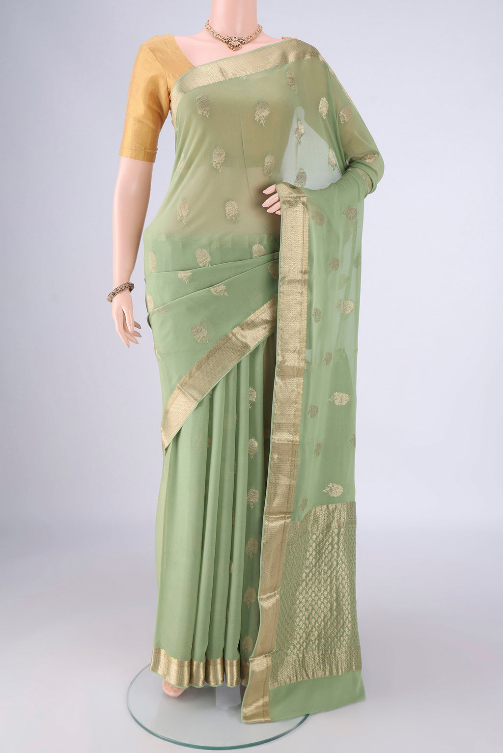 Pista Green Mysore Georgette Saree with Zari Butta on the body and Zari Border.  displayed on a mannequin