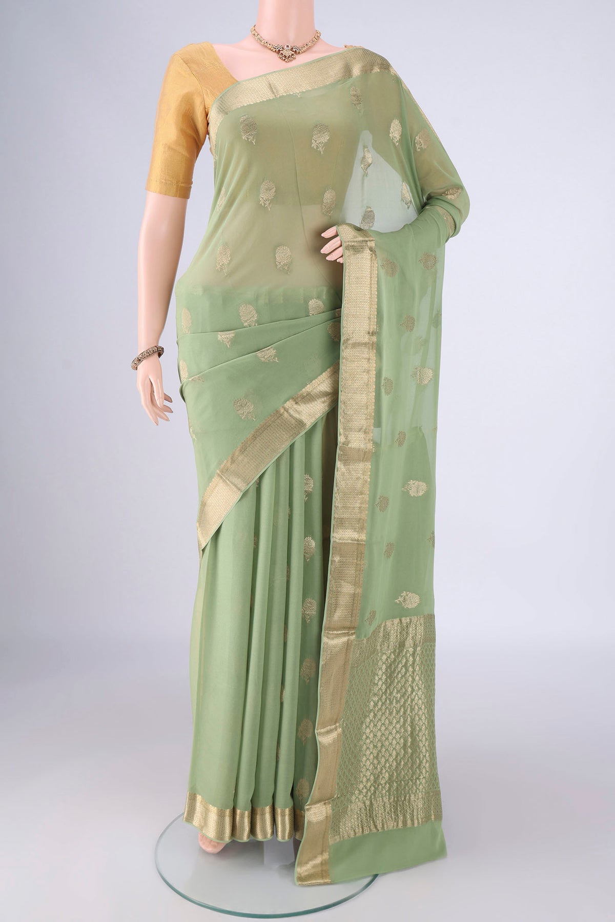 Pista Green Mysore Georgette Saree with Zari Butta on the body and Zari Border.  displayed on a mannequin
