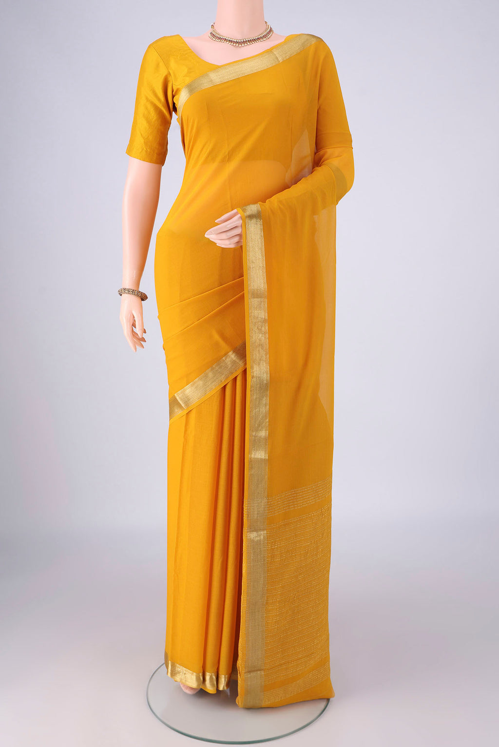 Yellow Mysore Georgette Saree with Plain Body and Zari Border.  displayed on a mannequin