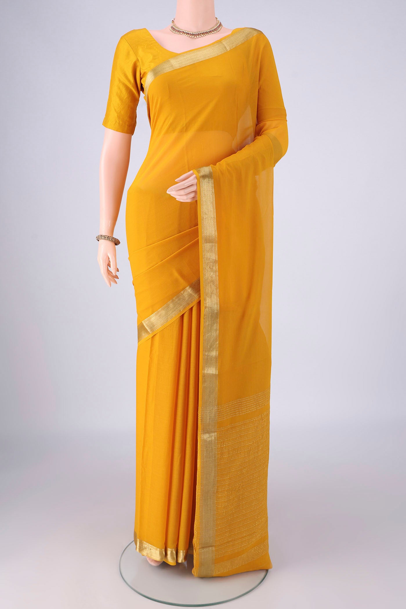 Yellow Mysore Georgette Saree with Plain Body and Zari Border.  displayed on a mannequin