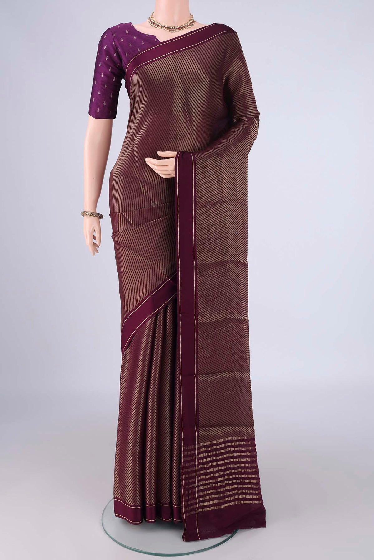 Burgundy Mysore Crepe Saree with Zari Butta on the body and Thin Zari Line.  displayed on a mannequin