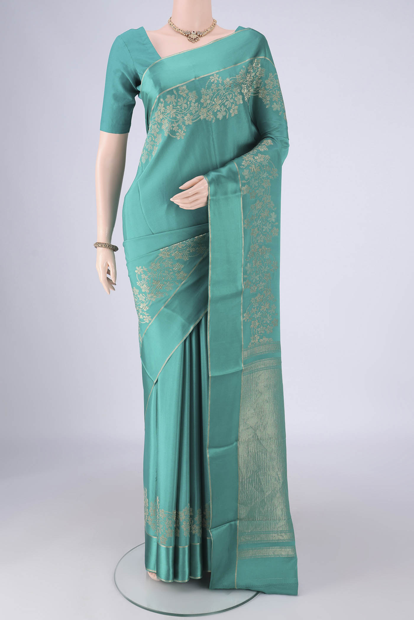 Sea Green Mysore Crepe Saree with Zari Butta on the body and Thin Zari Line.  displayed on a mannequin