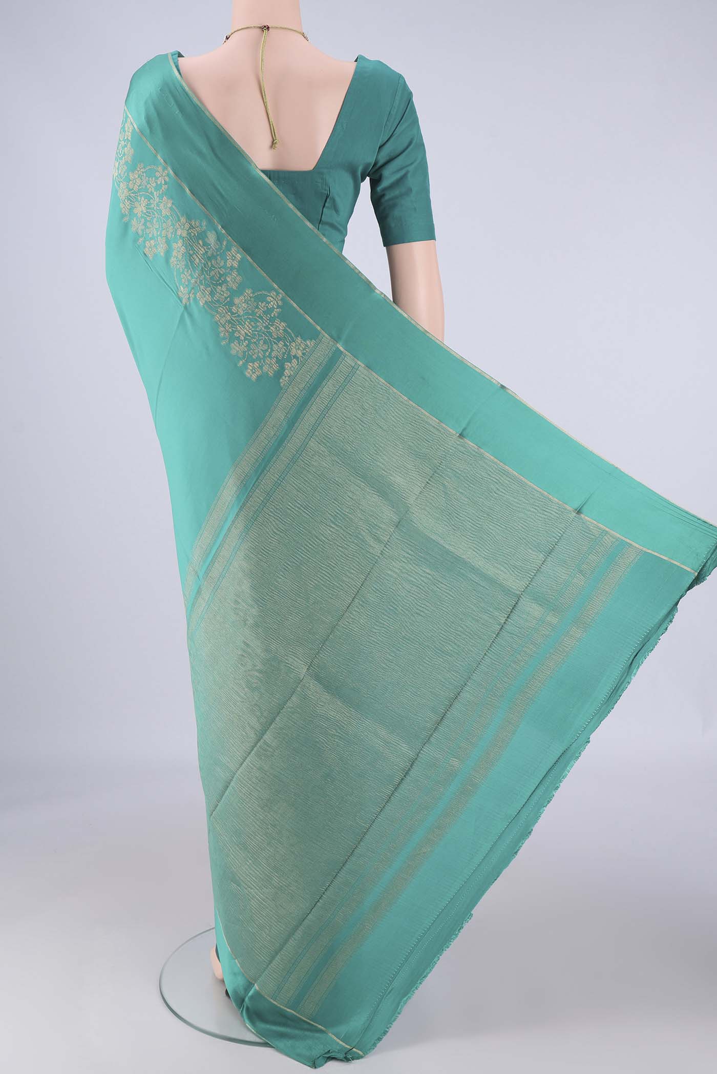Flat view of Sea Green Mysore Crepe Saree with Zari Butta on the body and Thin Zari Line. 