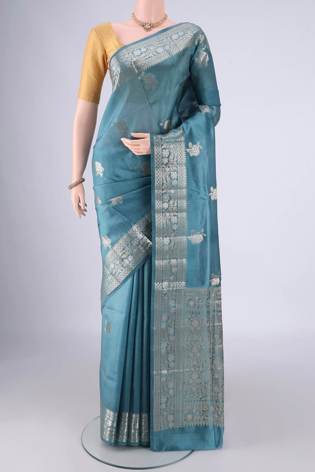 Maya Blue Banarasi Raw Silk Saree with Zari Butta on the body and Zari Border.  displayed on a mannequin