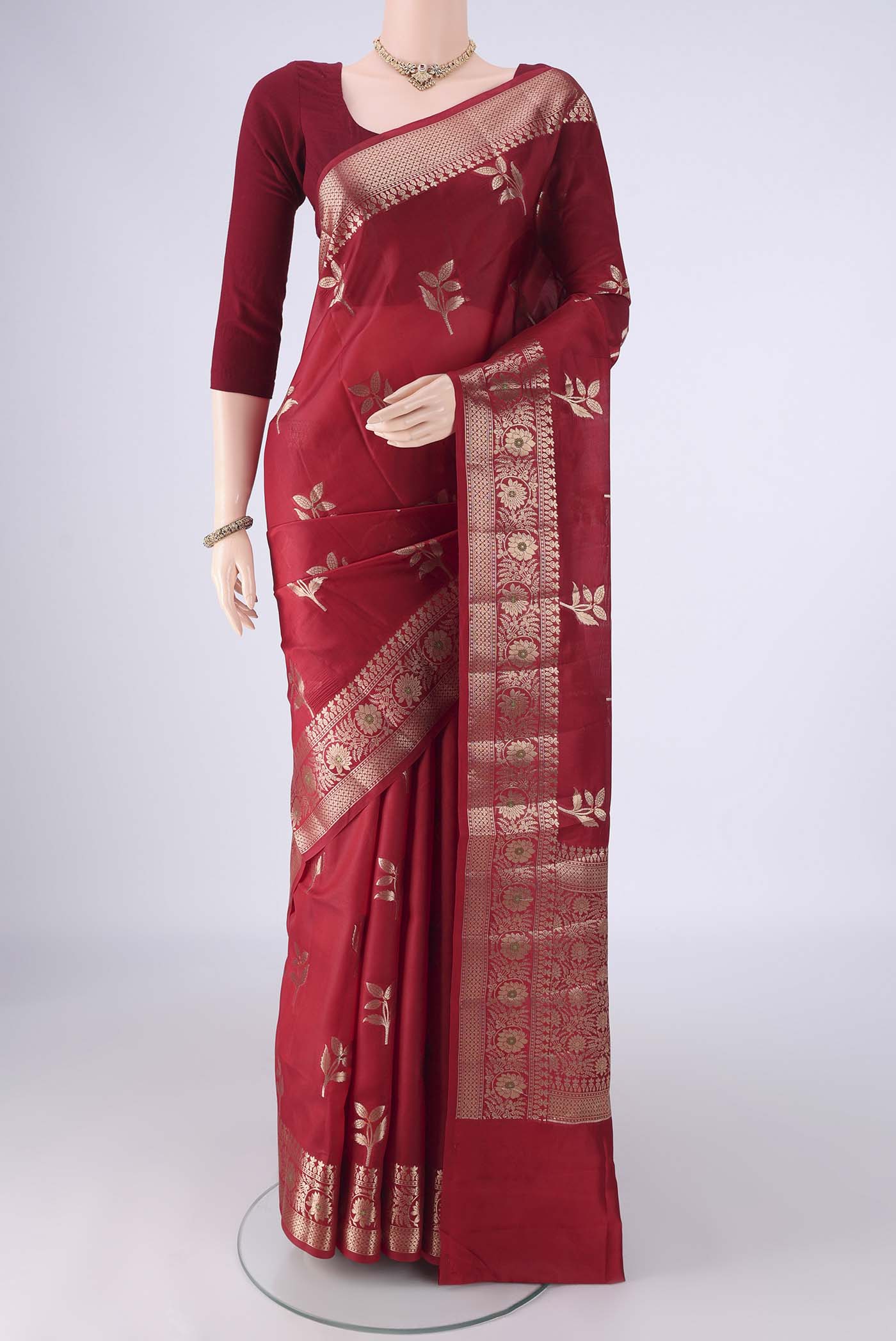 Maroon Banarasi Raw Silk Saree with Zari Butta on the body and Zari And Thread Border.  displayed on a mannequin
