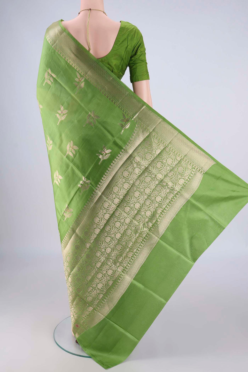 Flat view of Green Banarasi Raw Silk Saree with Zari And Thread Butta on the body and Zari And Thread Border. 