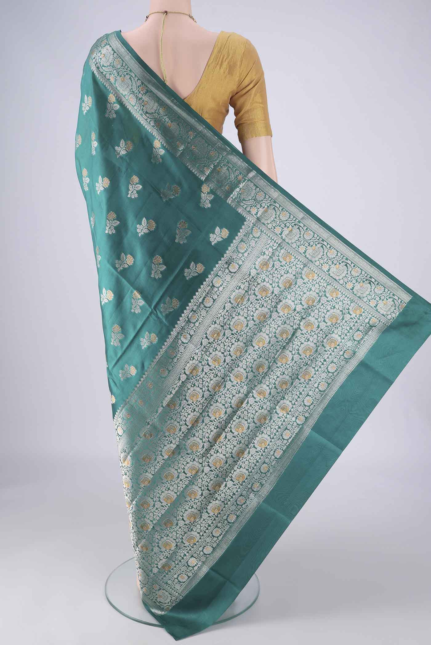 Flat view of Sea Green Banarasi Raw Silk Saree with Zari Butta on the body and Zari Border. 