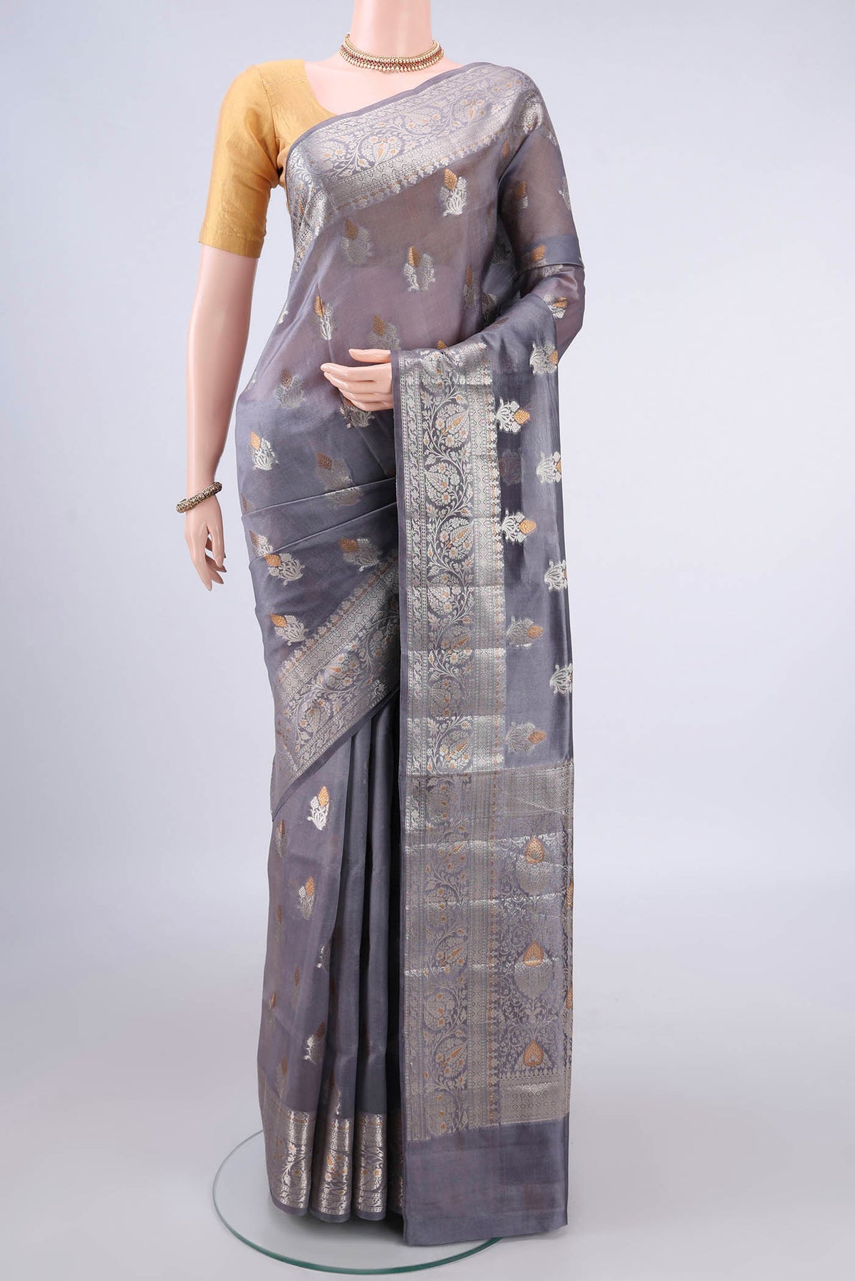 Pure Silk Grey Banarasi Raw Saree with Zari And Thread Butta on the body and Zari Border.  displayed on a mannequin