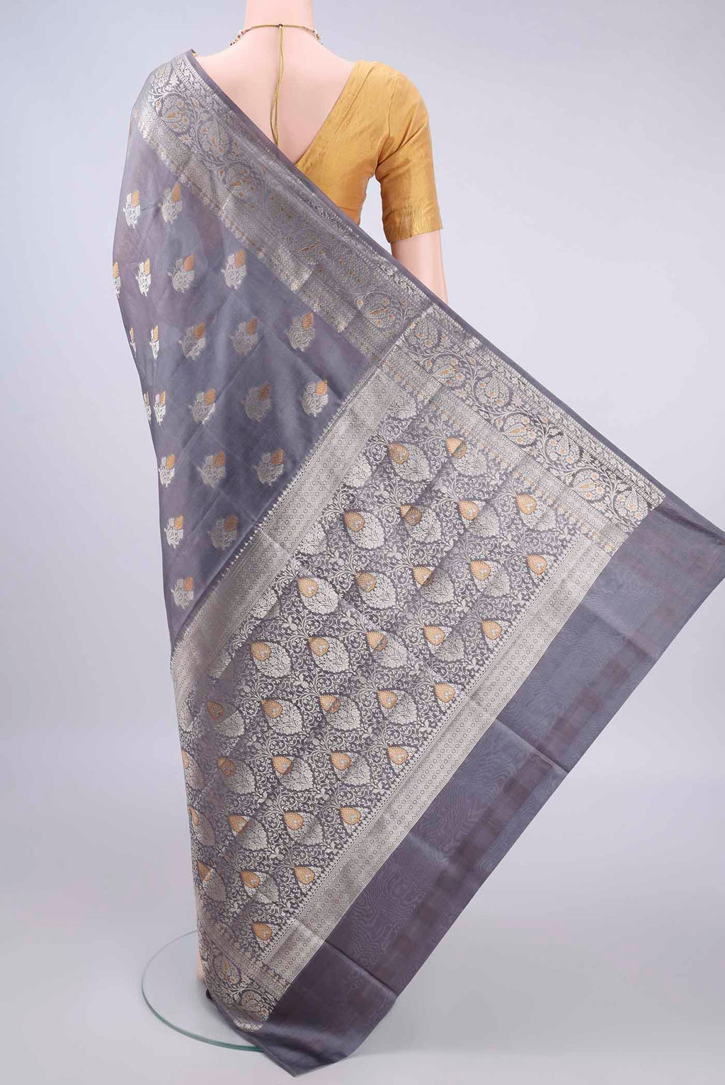Flat view of Pure Silk Grey Banarasi Raw Saree with Zari And Thread Butta on the body and Zari Border. 