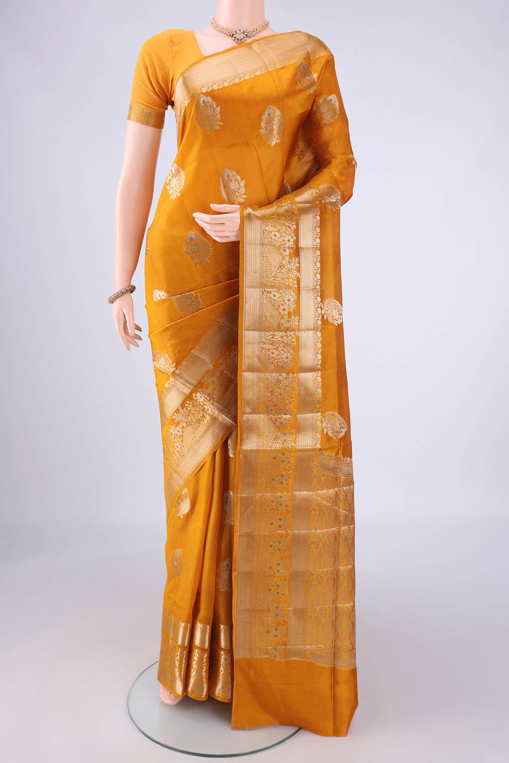 Mustard Banarasi Raw Silk Saree with Zari Butta on the body and Zari Border.  displayed on a mannequin