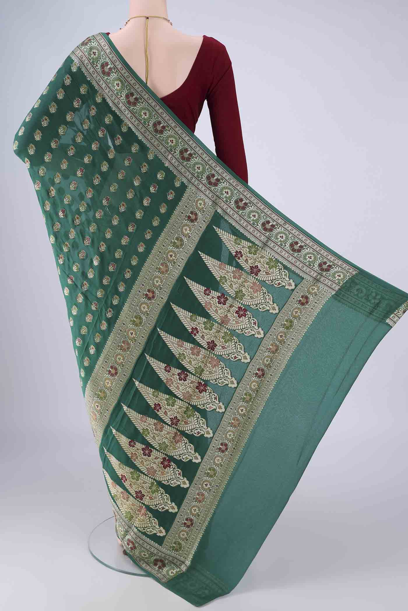 Flat view of Green Blended Banarasi Georgette Saree with Zari And Thread Butta on the body and Zari And Thread Border. 