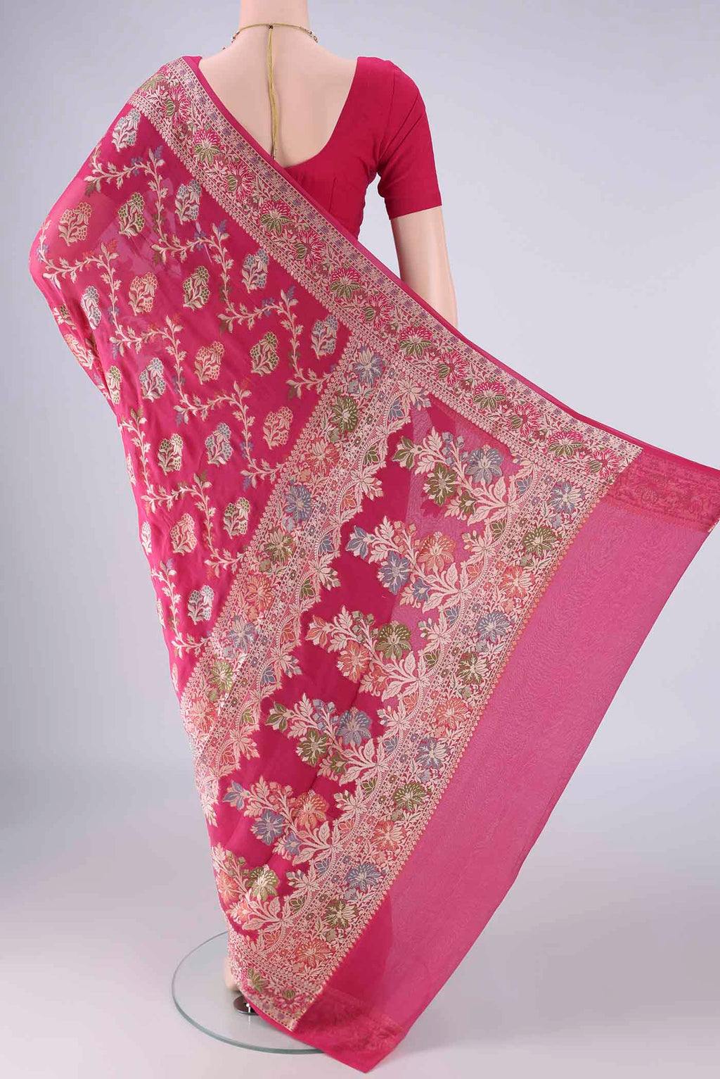 Flat view of Rani Pink Blended Banarasi Georgette Saree with Zari And Thread Butta on the body and Zari And Thread Border. 