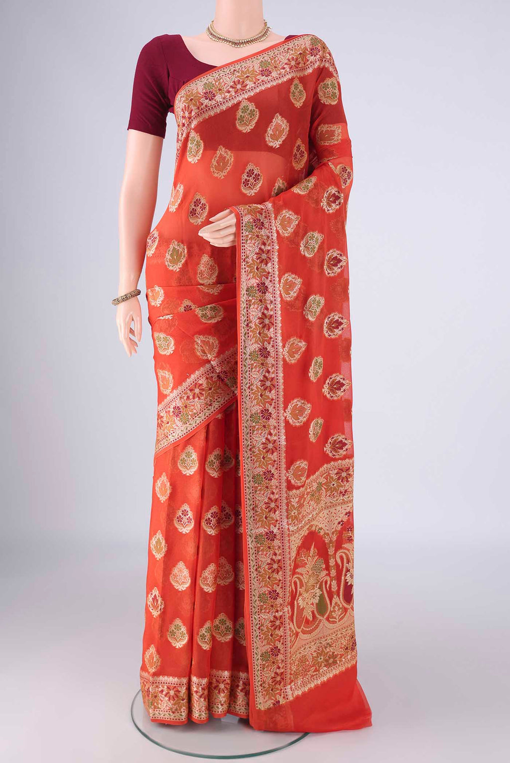 Rust Blended Banarasi Georgette Saree with Thread Butta on the body and Zari And Thread Border.  displayed on a mannequin