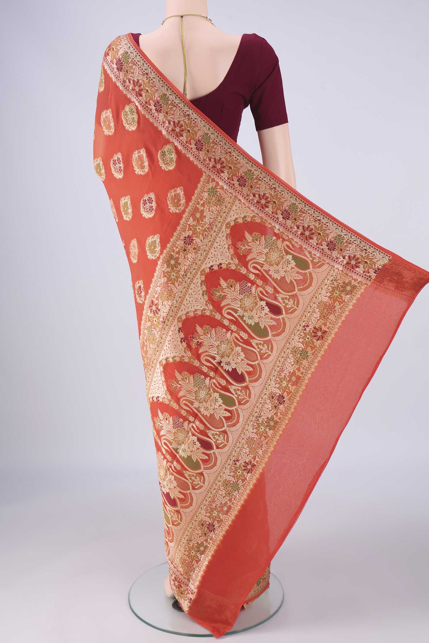 Flat view of Rust Blended Banarasi Georgette Saree with Thread Butta on the body and Zari And Thread Border. 