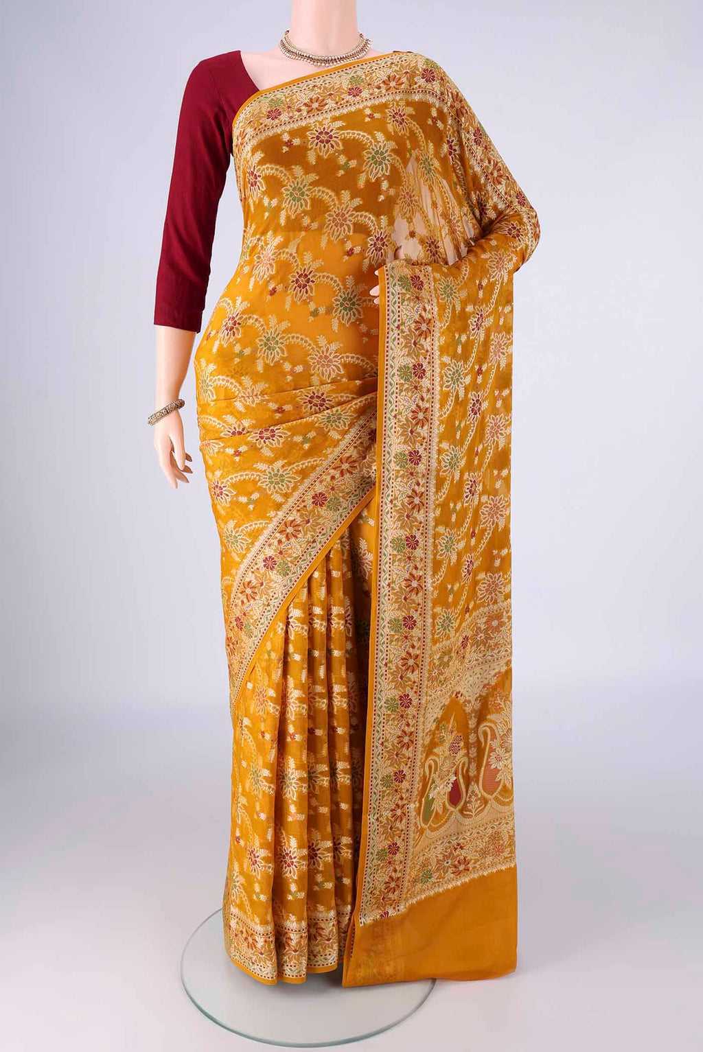 Mustard Blended Banarasi Georgette Saree with Zari Brocade on the body and Zari And Thread Border.  displayed on a mannequin