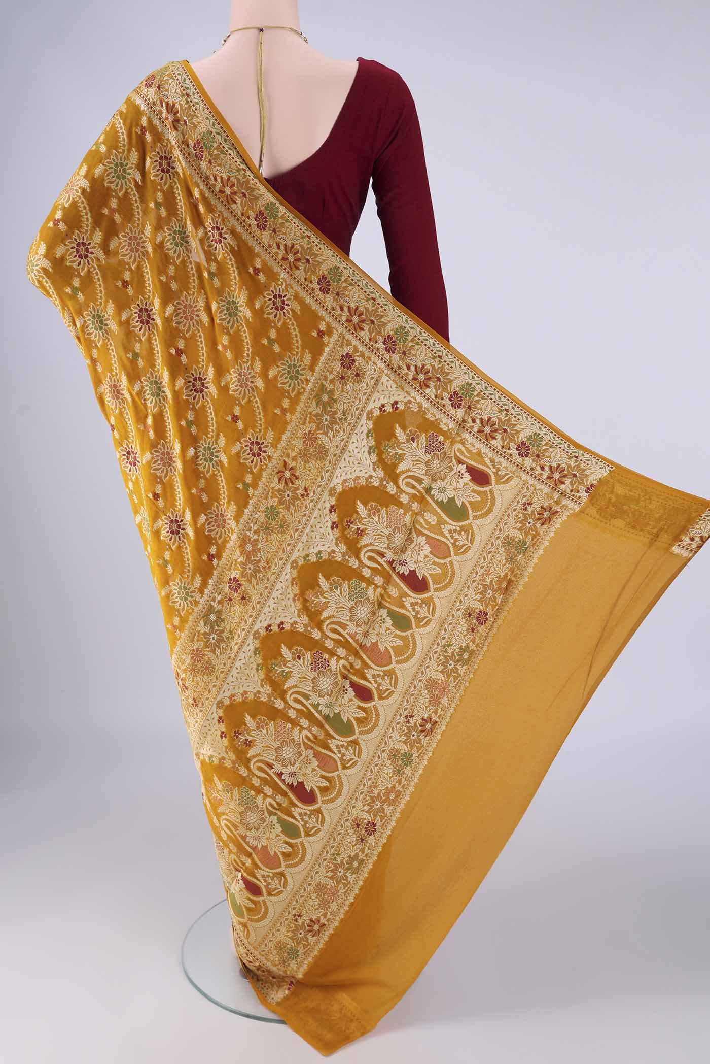 Flat view of Mustard Blended Banarasi Georgette Saree with Zari Brocade on the body and Zari And Thread Border. 