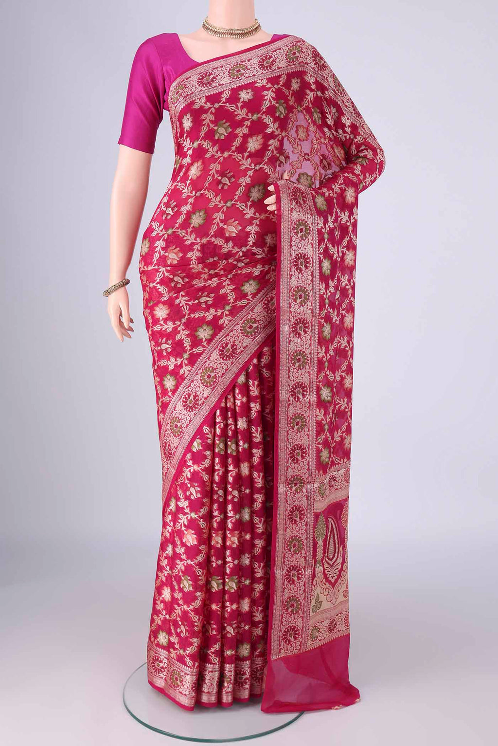 Rani Pink Blended Banarasi Georgette Saree with Thread Brocade on the body and Zari And Thread Border.  displayed on a mannequin
