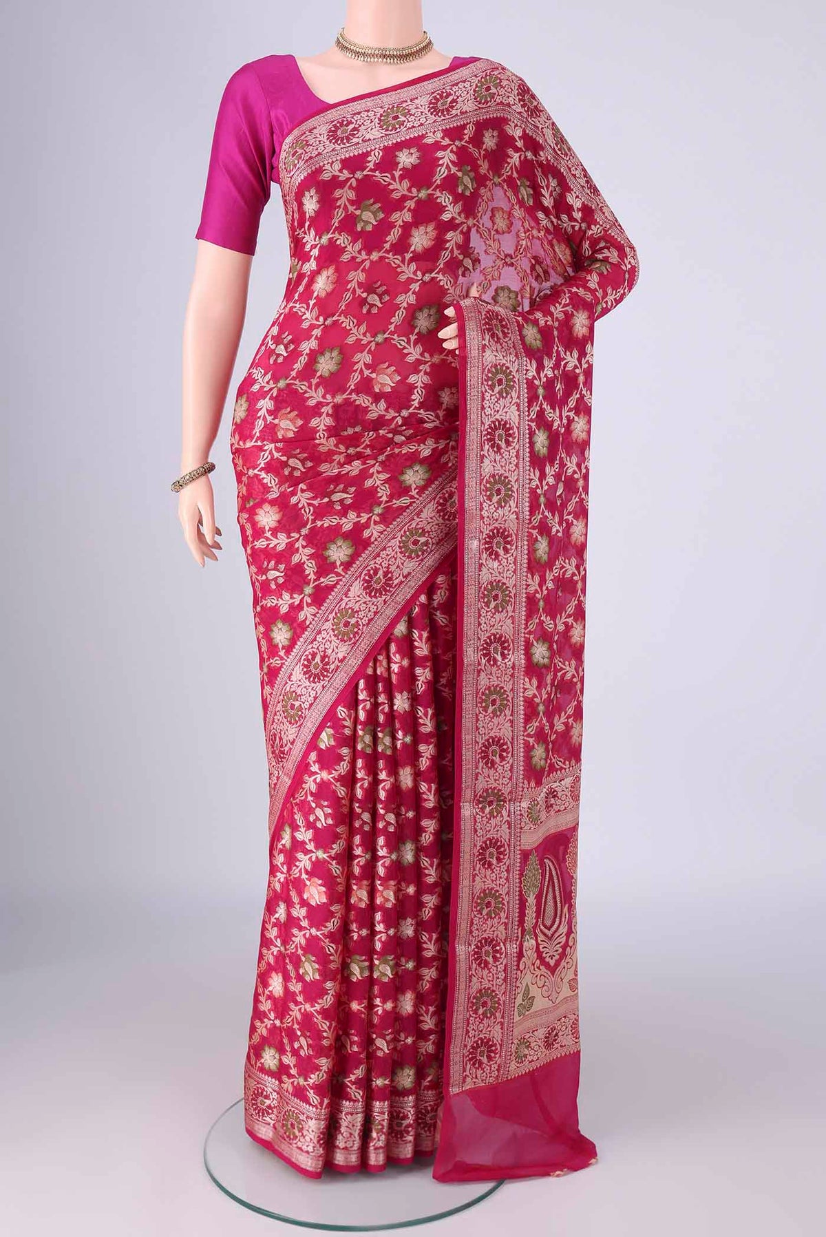 Rani Pink Blended Banarasi Georgette Saree with Thread Brocade on the body and Zari And Thread Border.  displayed on a mannequin
