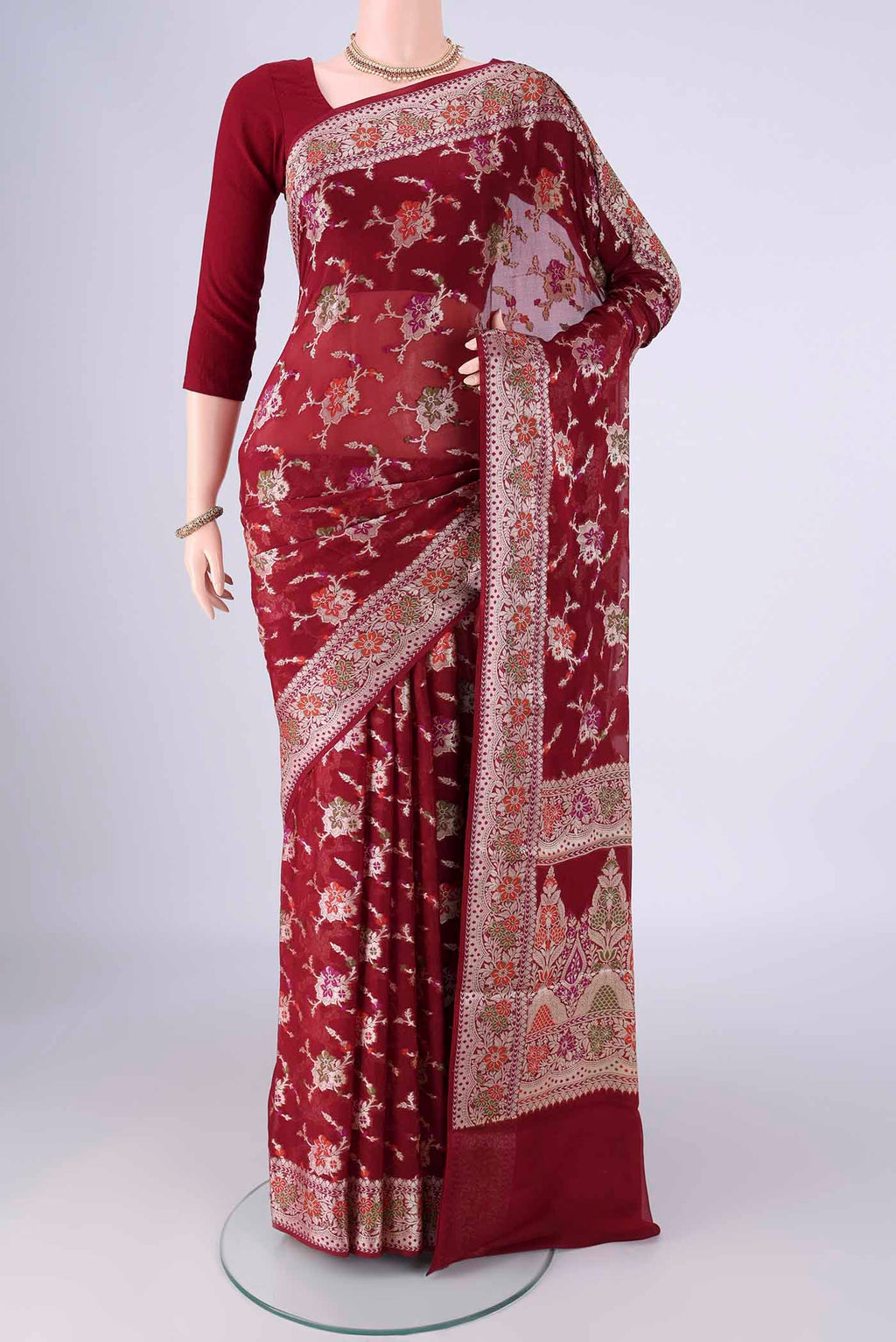 Maroon Blended Banarasi Georgette Saree with Zari And Thread Butta on the body and Zari And Thread Border.  displayed on a mannequin