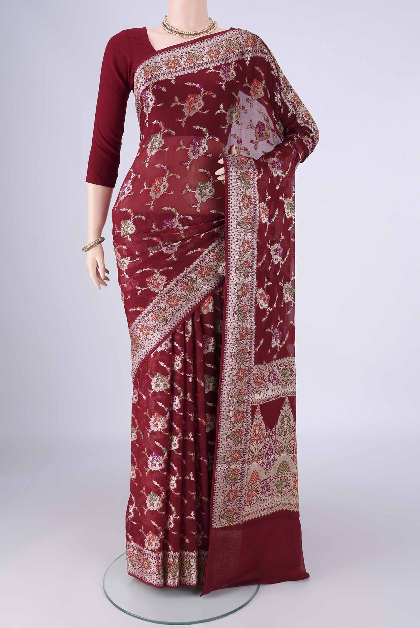 Maroon Blended Banarasi Georgette Saree with Zari And Thread Butta on the body and Zari And Thread Border.  displayed on a mannequin
