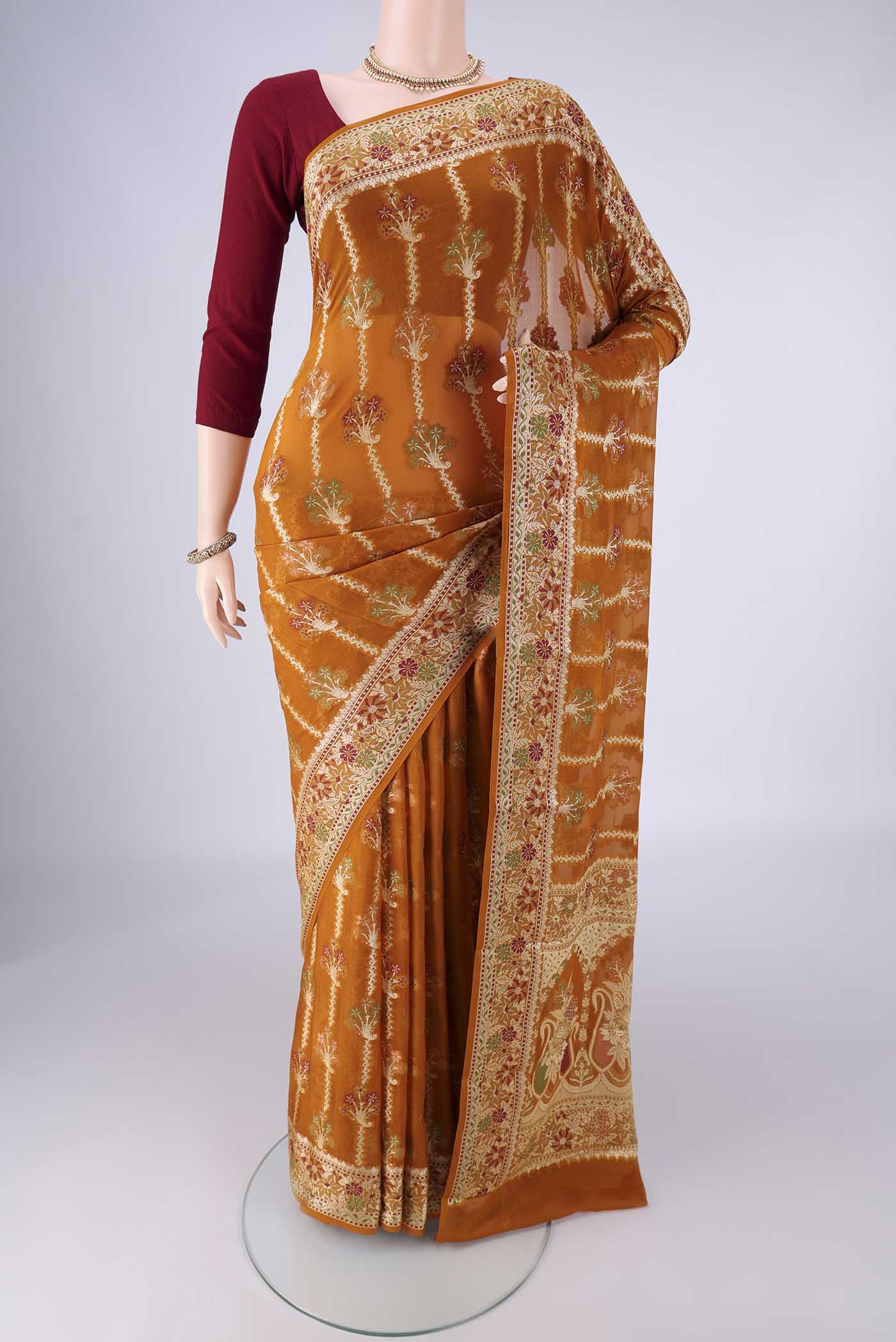 Mustard Blended Banarasi Georgette Saree with Zari And Thread Butta on the body and Zari And Thread Border.  displayed on a mannequin