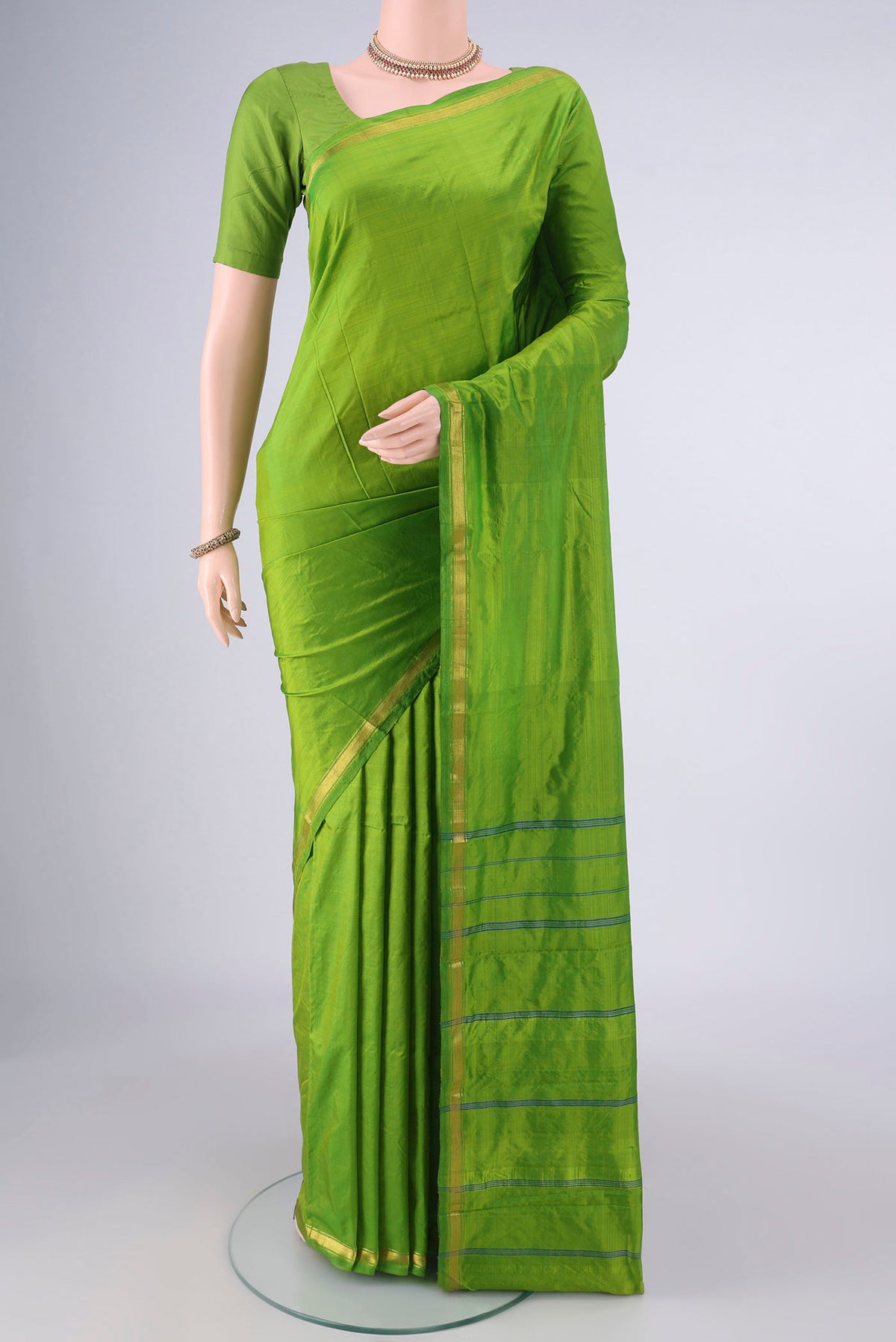 Pure Silk Parrot Green Kanchipuram Saree with Plain Body and Zari Border.  displayed on a mannequin
