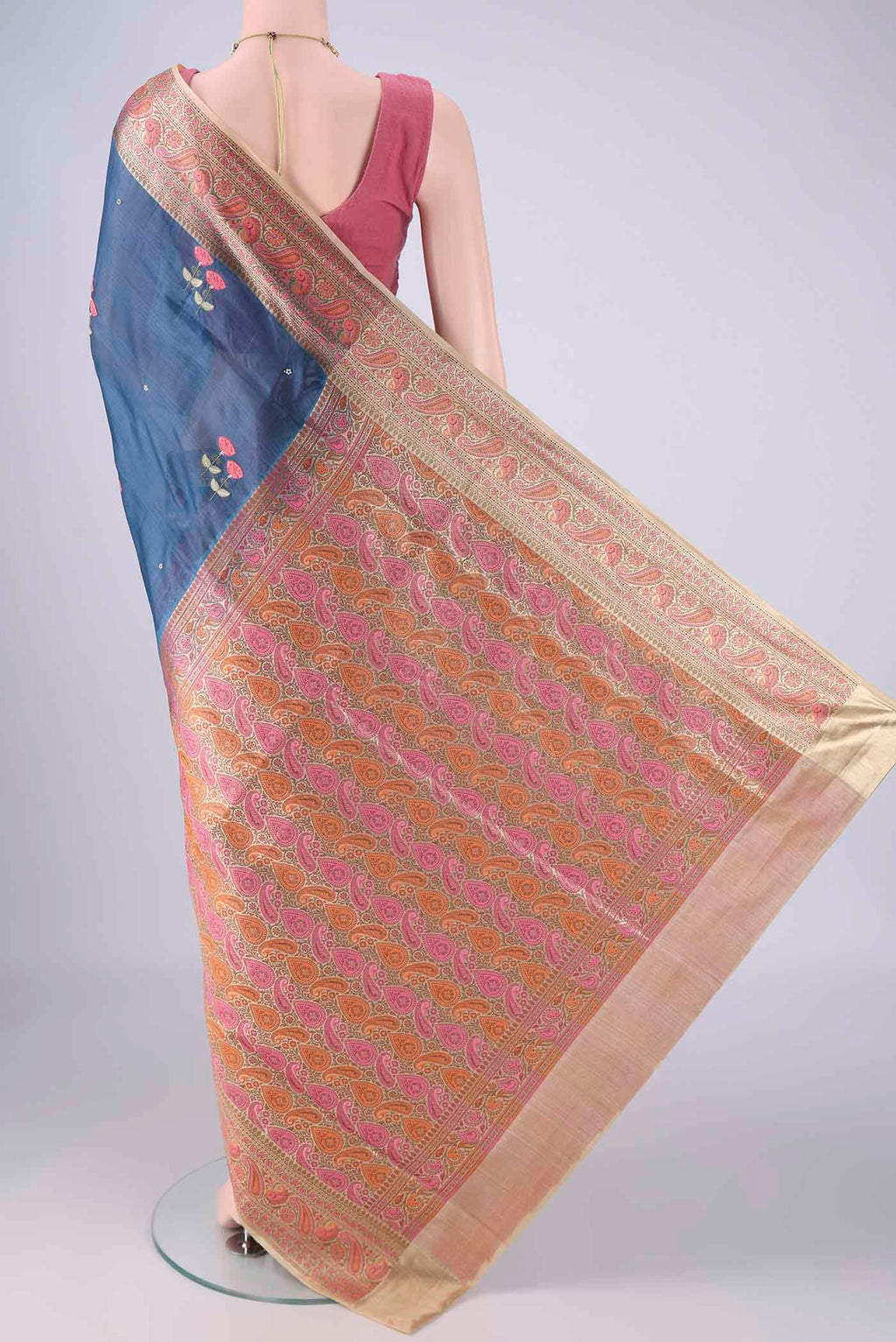 Flat view of Blue Banarasi Tussar Silk Saree with Embroidery on the body and Zari Border. 