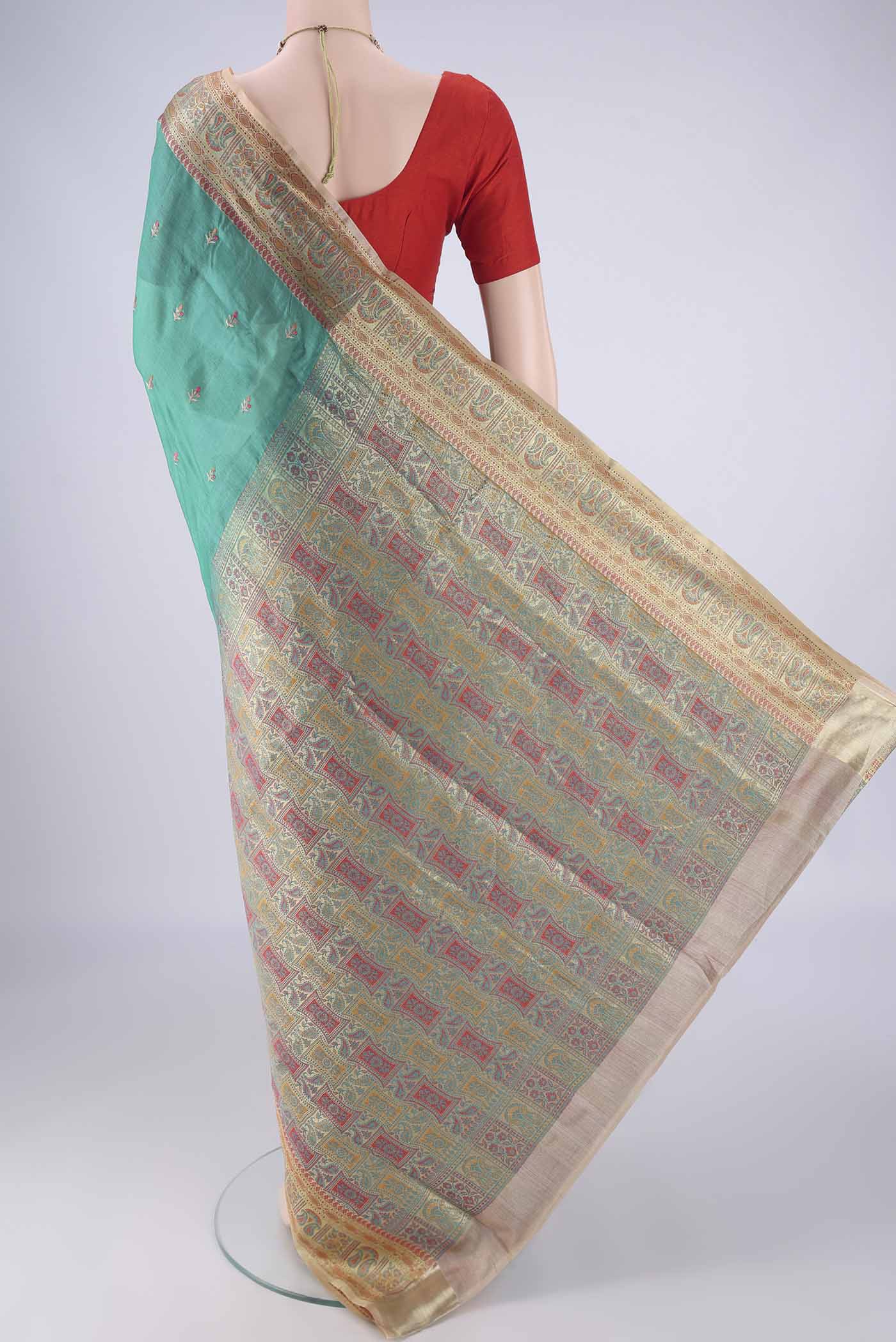 Flat view of Sea Green Banarasi Tussar Silk Saree with Embroidery on the body and Zari Border. 